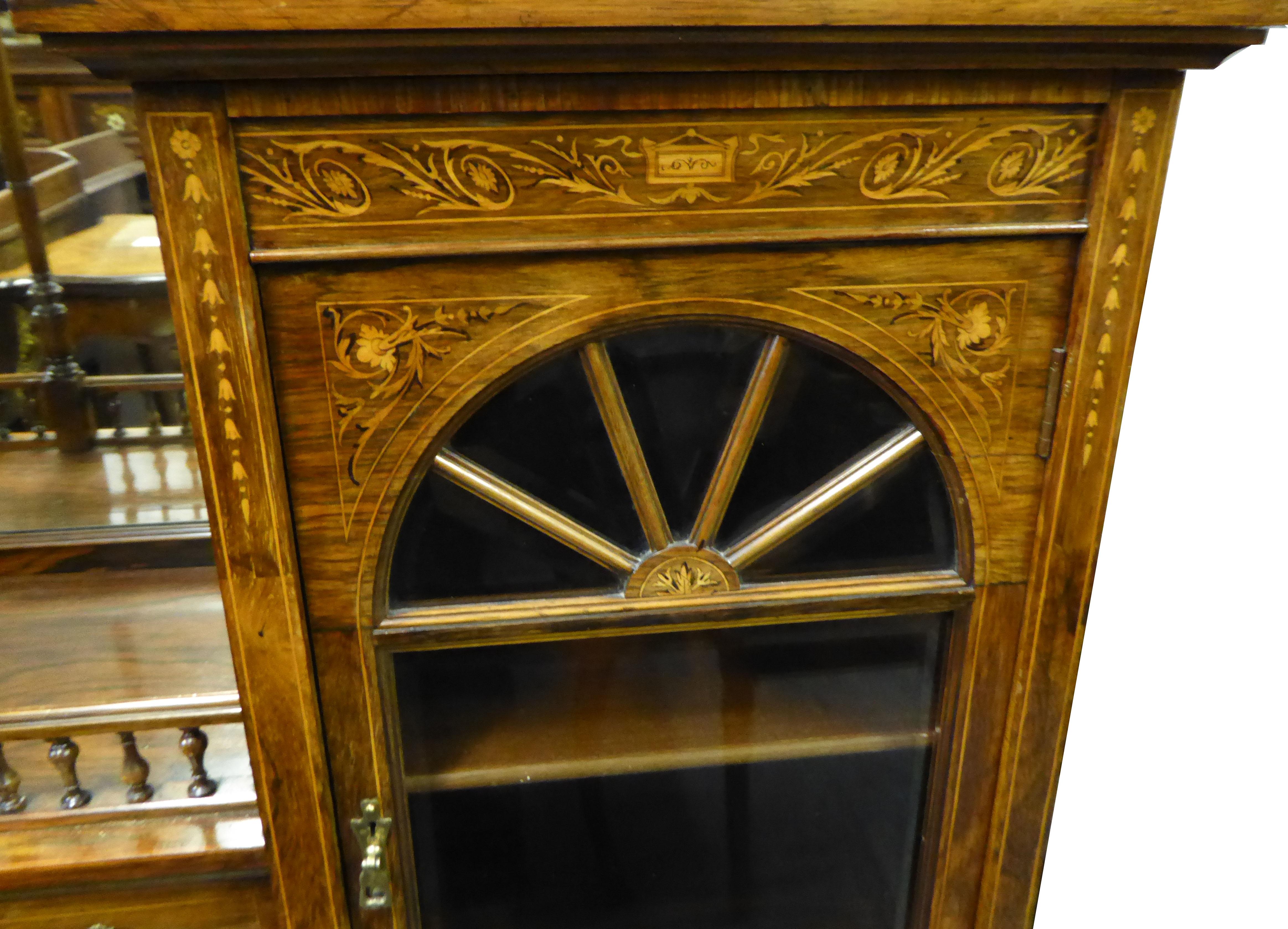 For sale is a very good quality Edwardian rosewood and inlaid cabinet. The top of the cabinet has three beveled mirrors, with two cabinet sections, one on each side, both with glazed doors opening to reveal ample storage space. The center of the