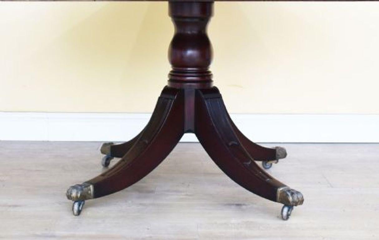 For sale is an Edwardian Mahogany Drum Table. The table has a leather top, with decorative gold tooling and centre motif. Below this, there are four drawers, one in each side, each drawer is flanked by a dummy drawer. This is above a turned column