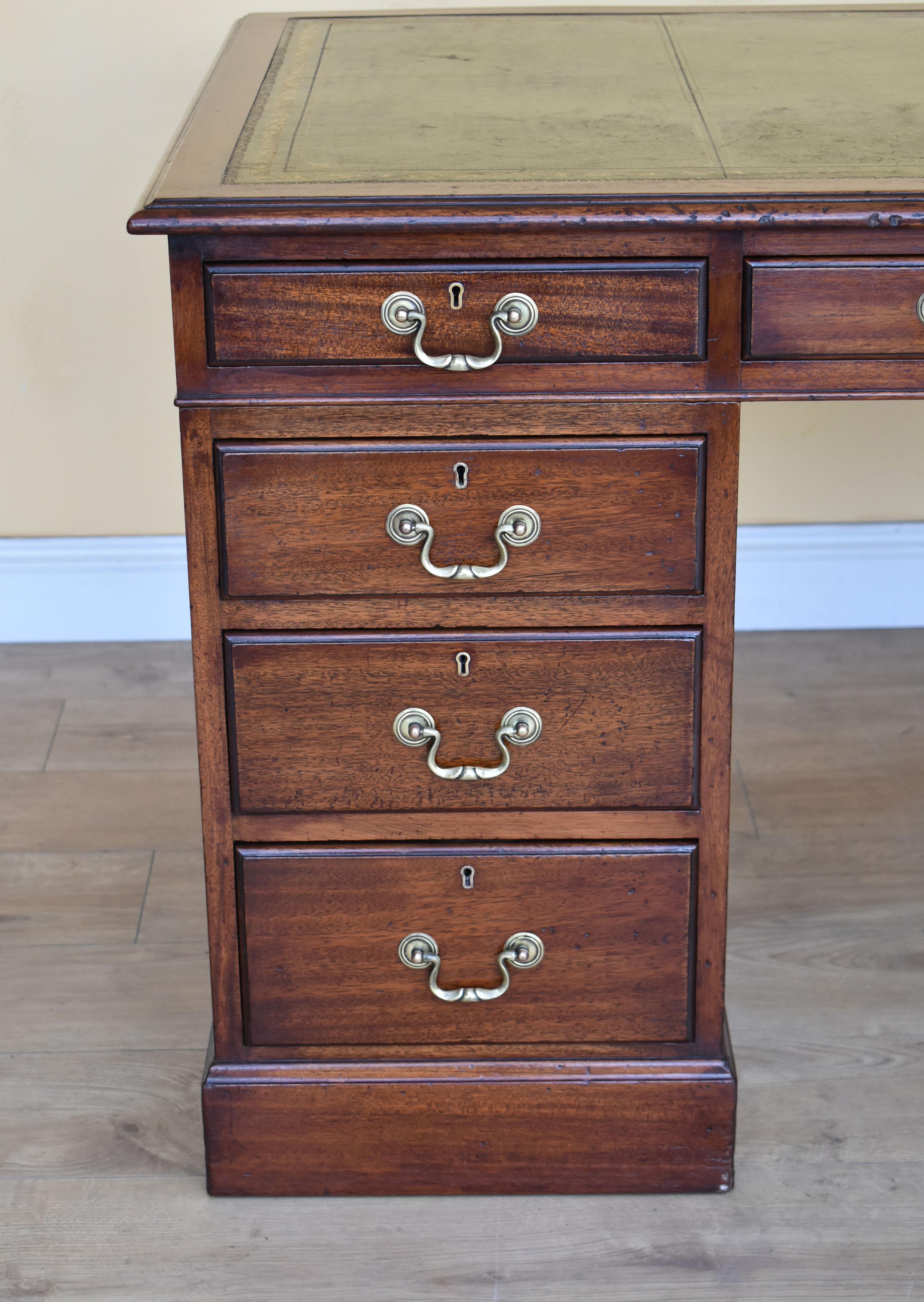 For sale is an early 20th century Edwardian mahogany pedestal desk. The top has an inset green leather with decorative gold tooling above three drawers in the top, one long in the centre, flanked by a short drawer on each side. The top fits onto two