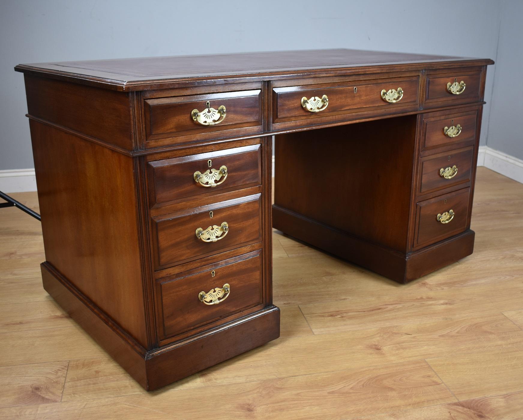 For sale is a good quality Edwardian red walnut pedestal desk. The top of the desk has a maroon leather insert with decorative tooling, above three drawers. The top fits onto two pedestals, each with a further three graduated drawers each with