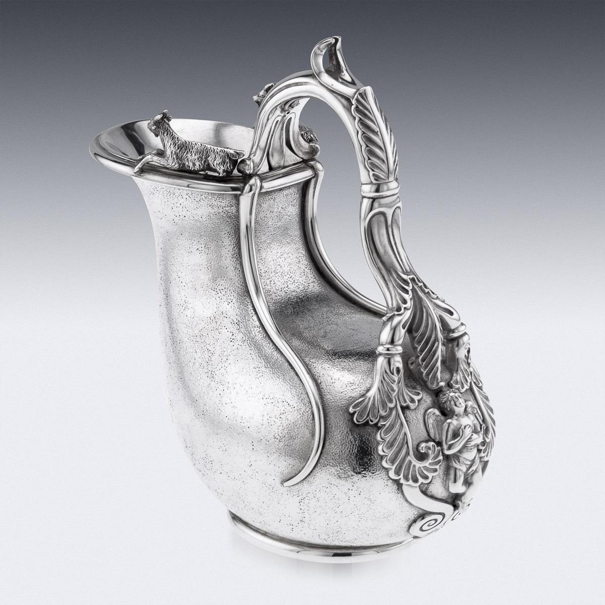 20th Century Edwardian silver Askos jug, applied with an openwork acanthus-capped handle with putto terminal on matted ground, the rim applied with two fully-modeled rams, inside richly parcel gilt.
Hallmarked English silver, London, year 1905 (k),