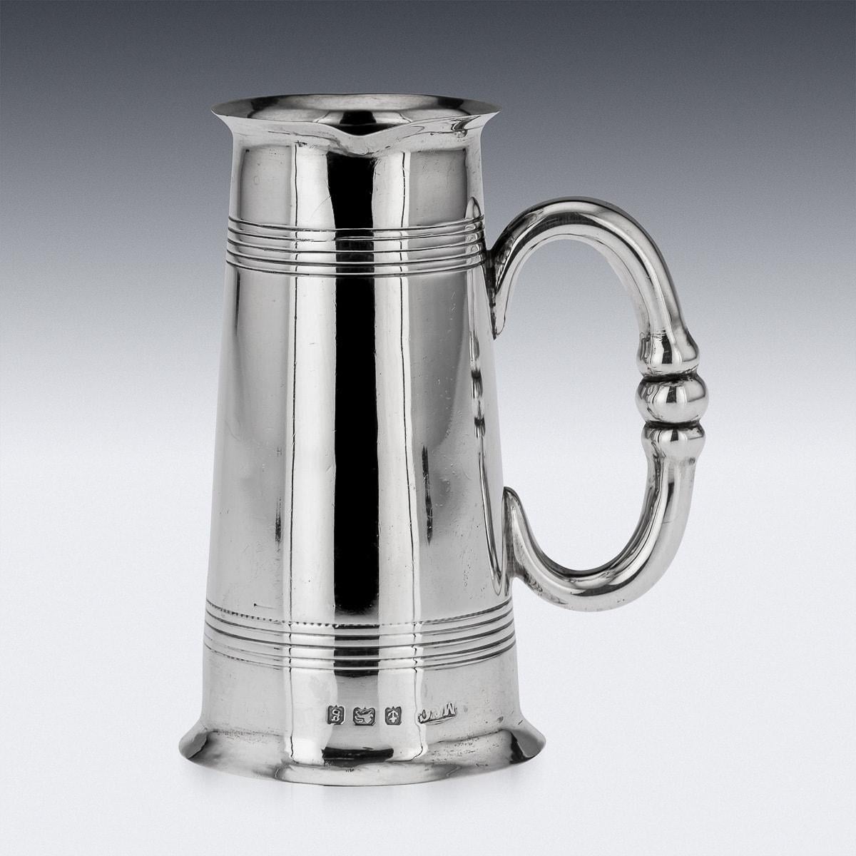 Antique early 20th Century Edwardian solid silver tankard of traditional form. The tankard consists of a flared upper rim and pouring spout, a C-shaped handle, the belly is decorated with reeded bands which are engraved and which terminates in a