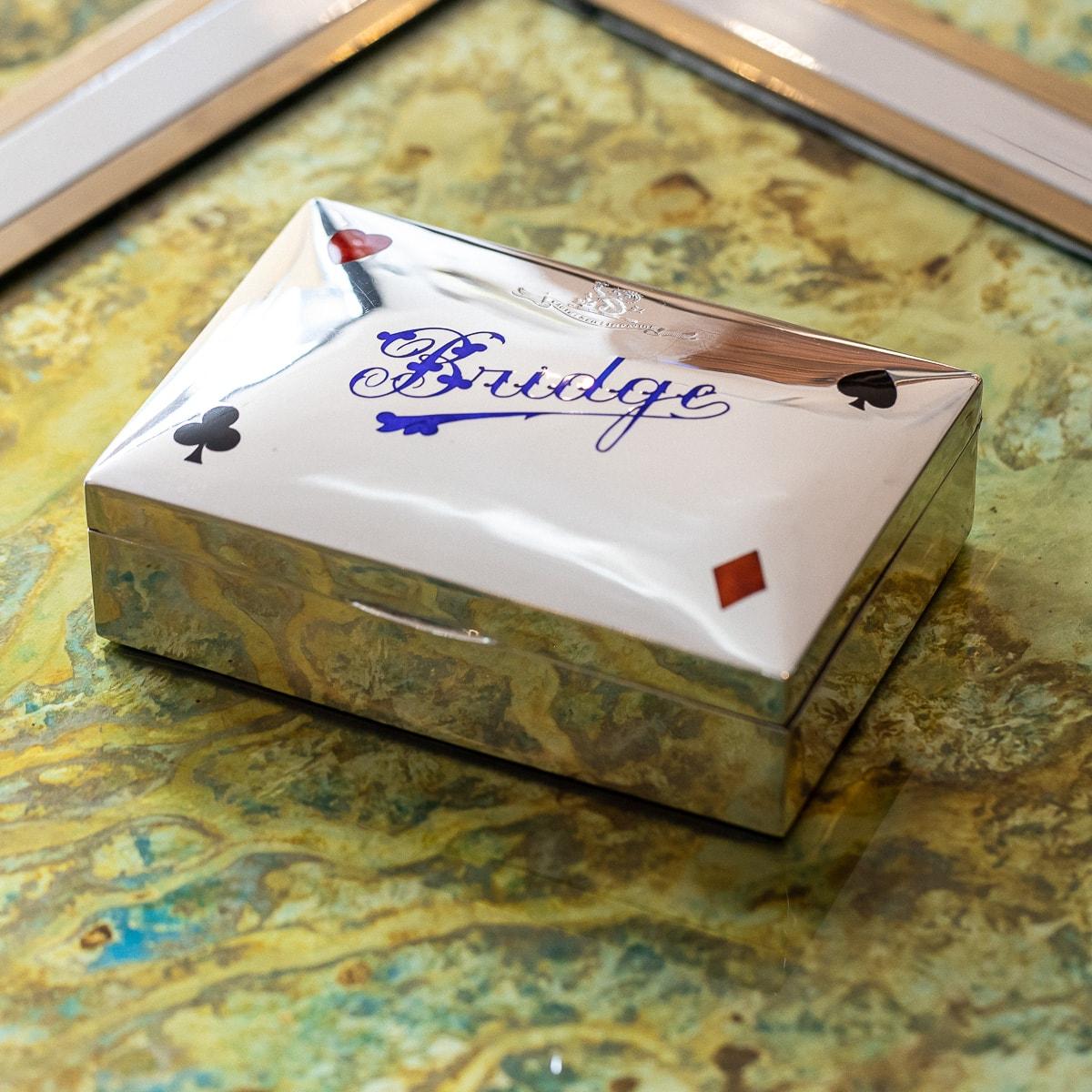 Antique early-20th century Edwardian solid silver & enamel bridge gaming box, the plain silver box applied to the lid with a stylised Bridge writing and card suits, inside lined with leather and engraved with a crest 'CAUTE SED IMPAVIDE' - The