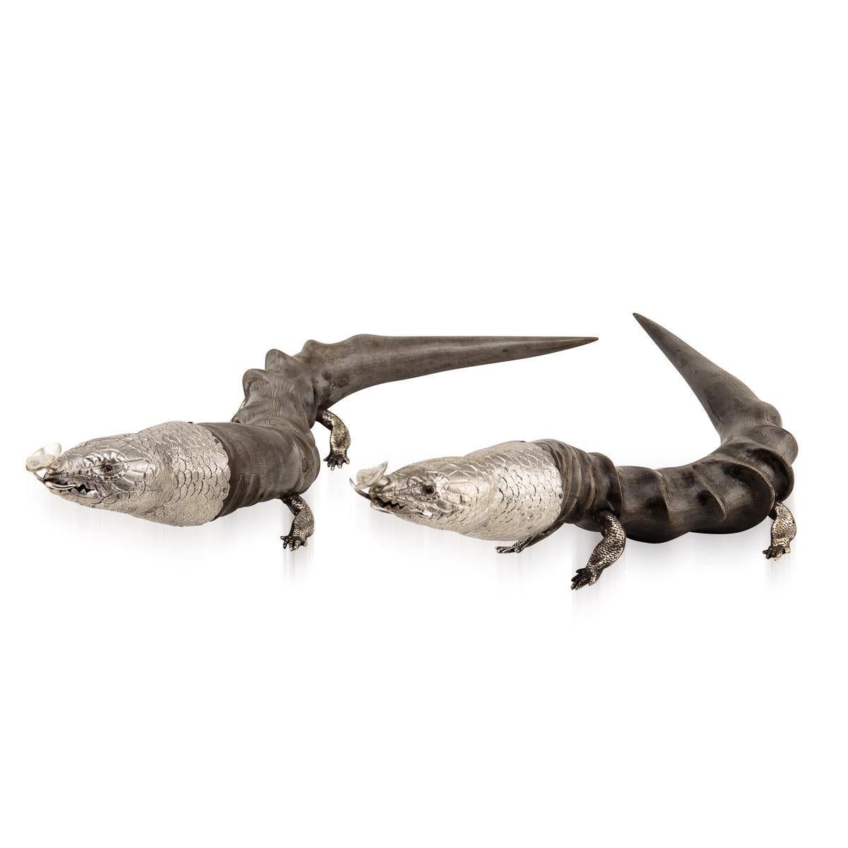 Antique early-20th Century Edwardian solid silver & horn mounted pair of table cigar lighters. The two blackbuck antelope horns are mounted with a silver lizard shaped heads, with the light wick pointing out of its mouth, resting on a four feet.