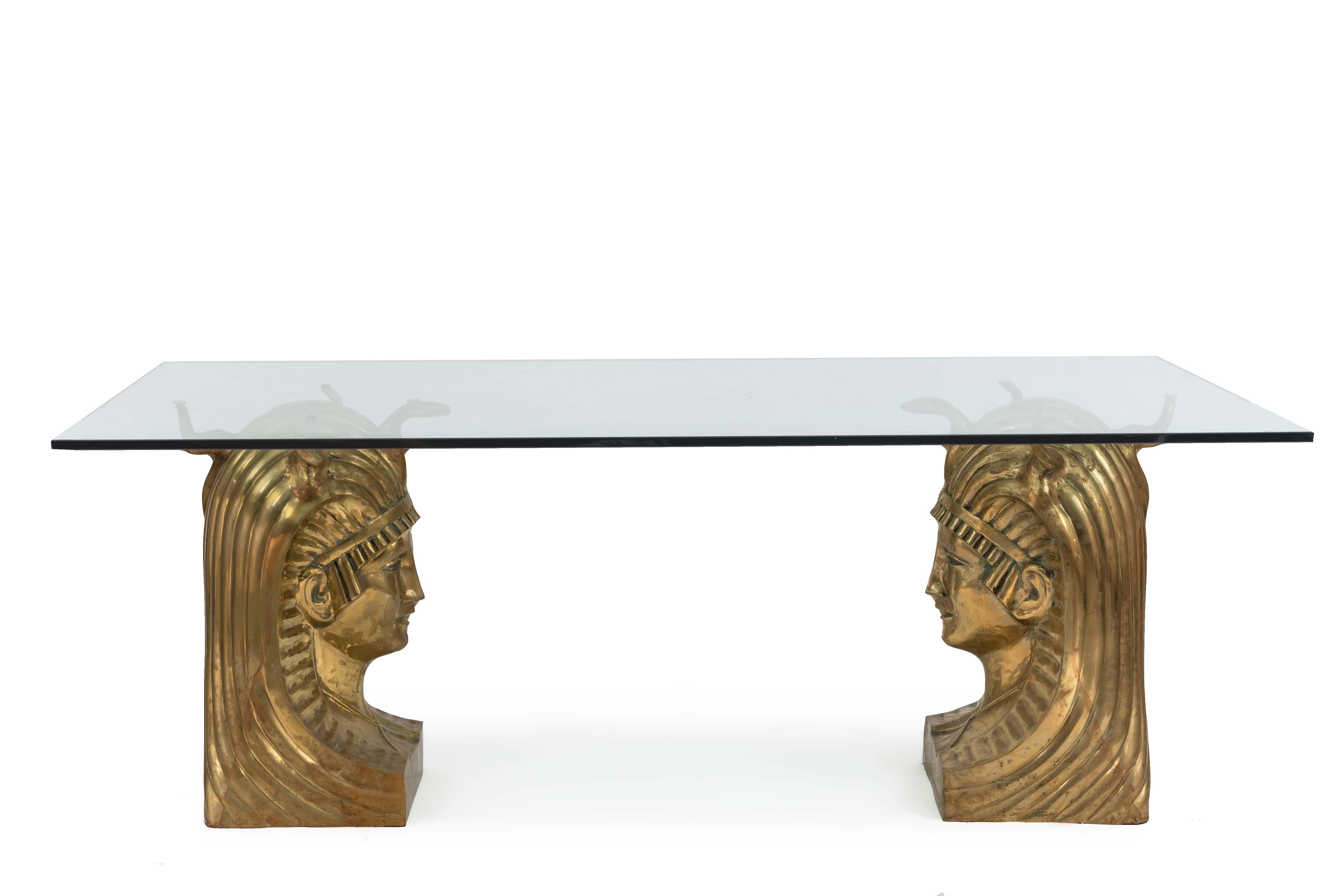 Midcentury American (1970s) dining table having a rectangular glass top supported by a pair of large bronze busts of a Pharaoh wearing a headdress.