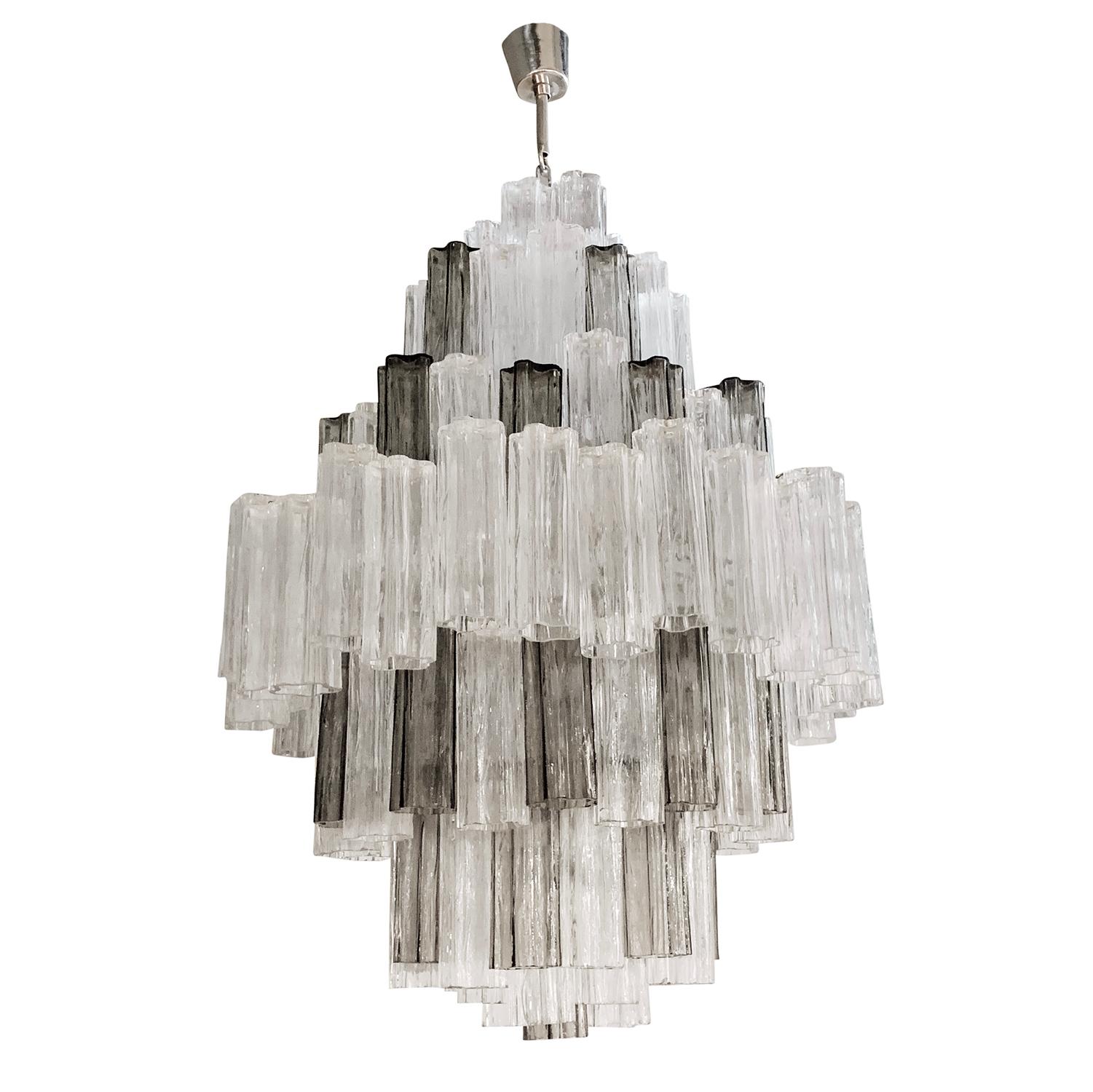 A large, vintage Mid-Century Modern Italian pair of chandeliers on a chrome base and multi-color handblown Murano glass in good condition. Each eight tiered pendant is composed with circa 150 Tronchi glass pieces, featuring six light sockets,