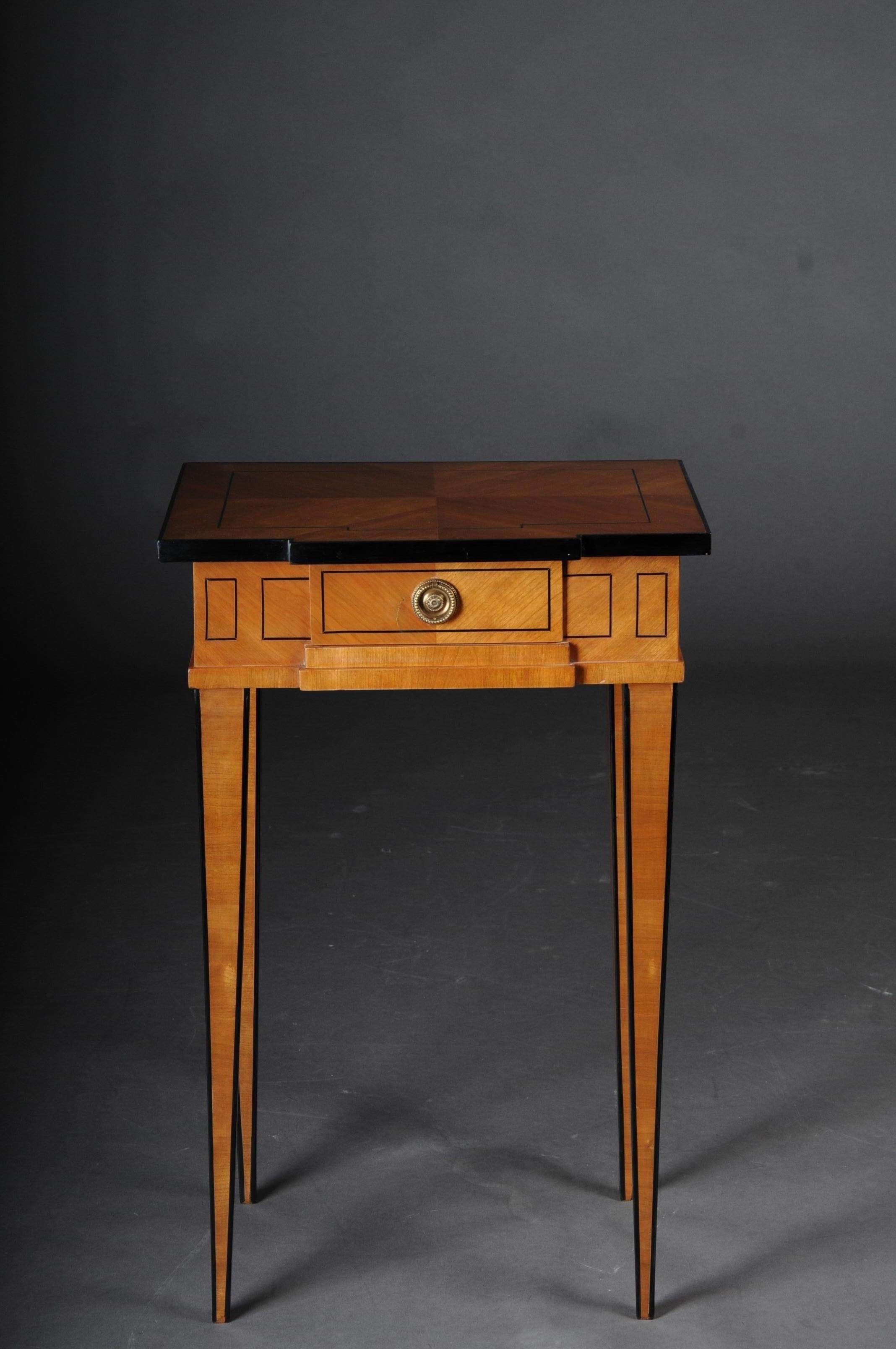 Elegant side table in classicistic style

Cherrywood veneer on fir, partially ebonized. Longitudinal rectangular sheet over a single-drawer, cut-out frame and square legs tapering downwards. Nice patina, hand polish with shellac.

(G-Sam-27).