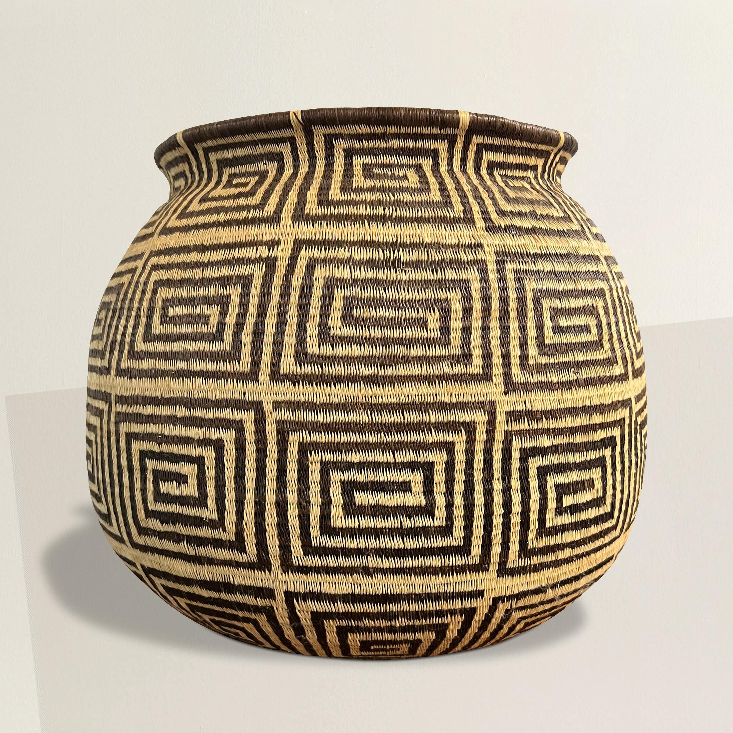 Dieser außergewöhnliche Emberá-Wounaan-Korb aus dem 20. Jahrhundert ist ein Zeugnis für die bemerkenswerte Handwerkskunst des indigenen Volkes der Emberá-Wounaan in Panama und Kolumbien. Mit unvergleichlicher Kunstfertigkeit aus natürlichen