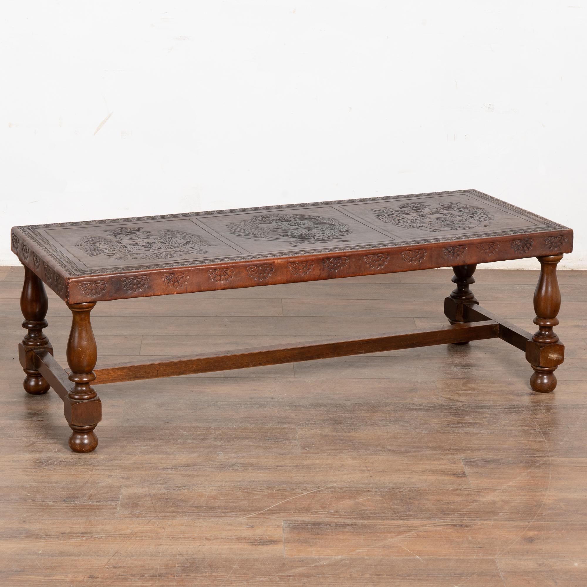 The warm patina of the aged leather adds to the character of this embossed leather top coffee table from Spain.
Note in photos the three embossed 