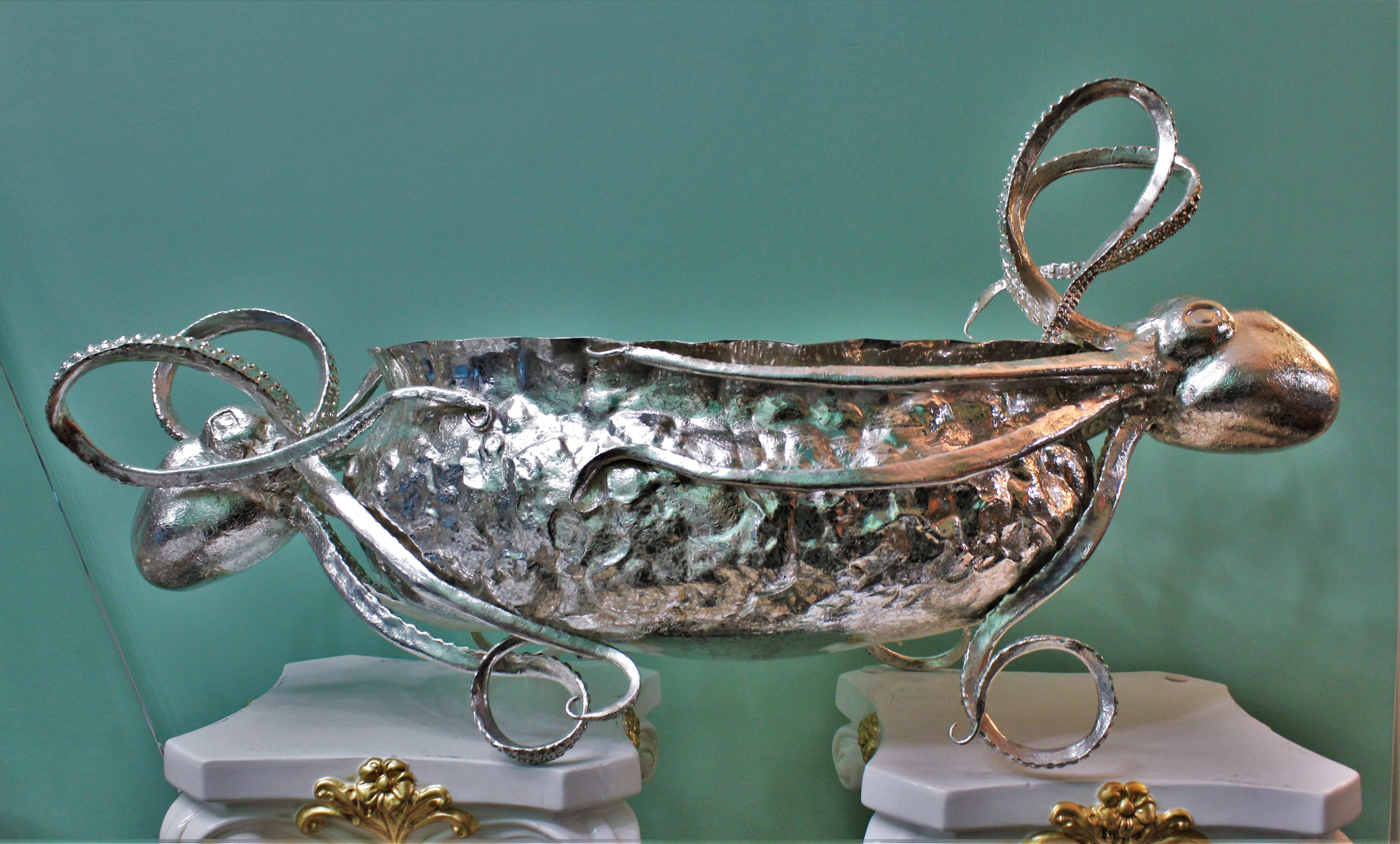 Impressive embossed silver oval centrepiece with an engraved cast octopus on each side.

Entirely hand crafted the oval basket is embossed by hand and hammered to make it look like a rock where the octopus are staying one on each side.

Extremely