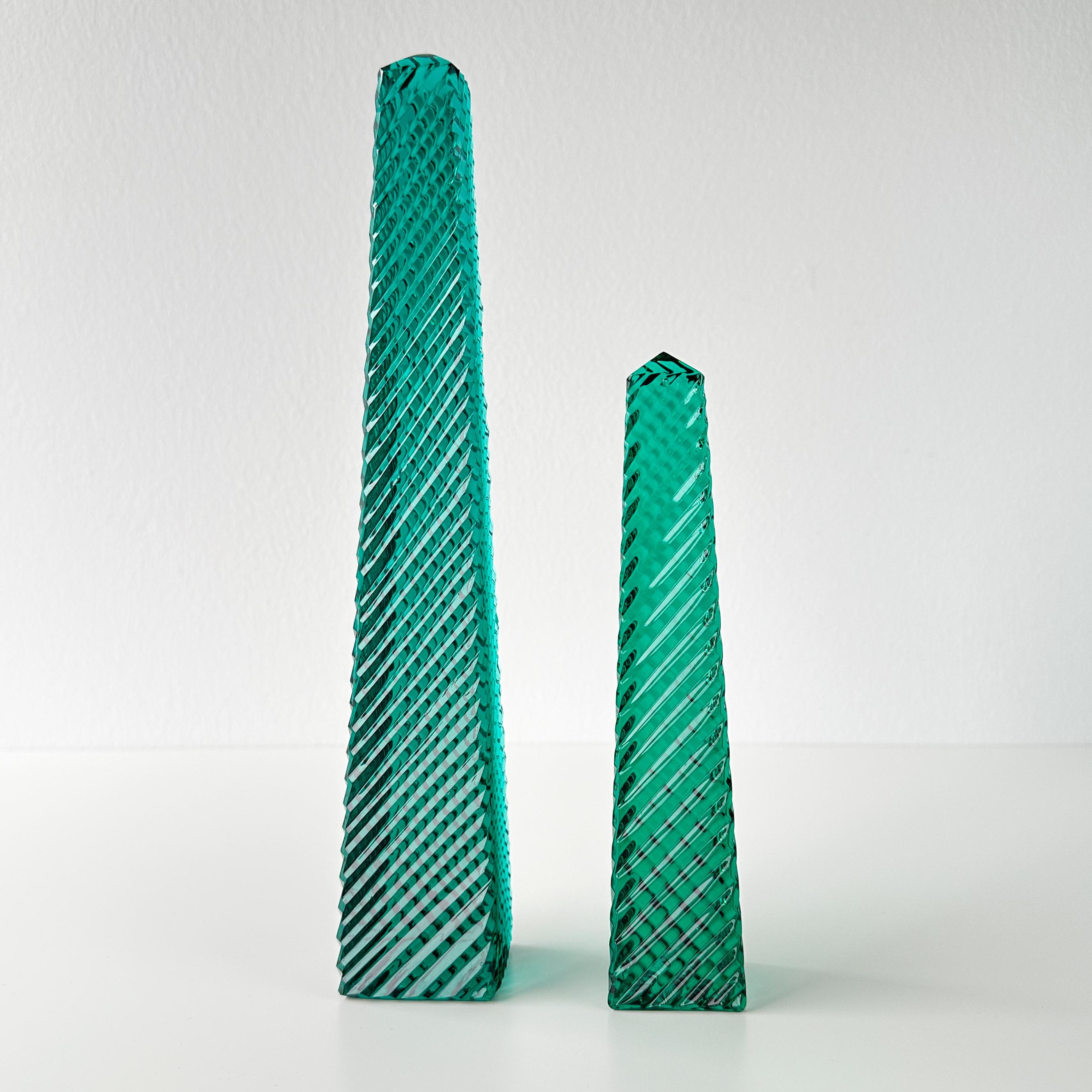 Vintage from a local estate pair of emerald green crystal glass obelisks. Cut with a diagonal pattern that gives movement to the pair. A clear crystal obelisk with the same design was made by Tiffany & Co. and inspired this pair. Circa mid to late