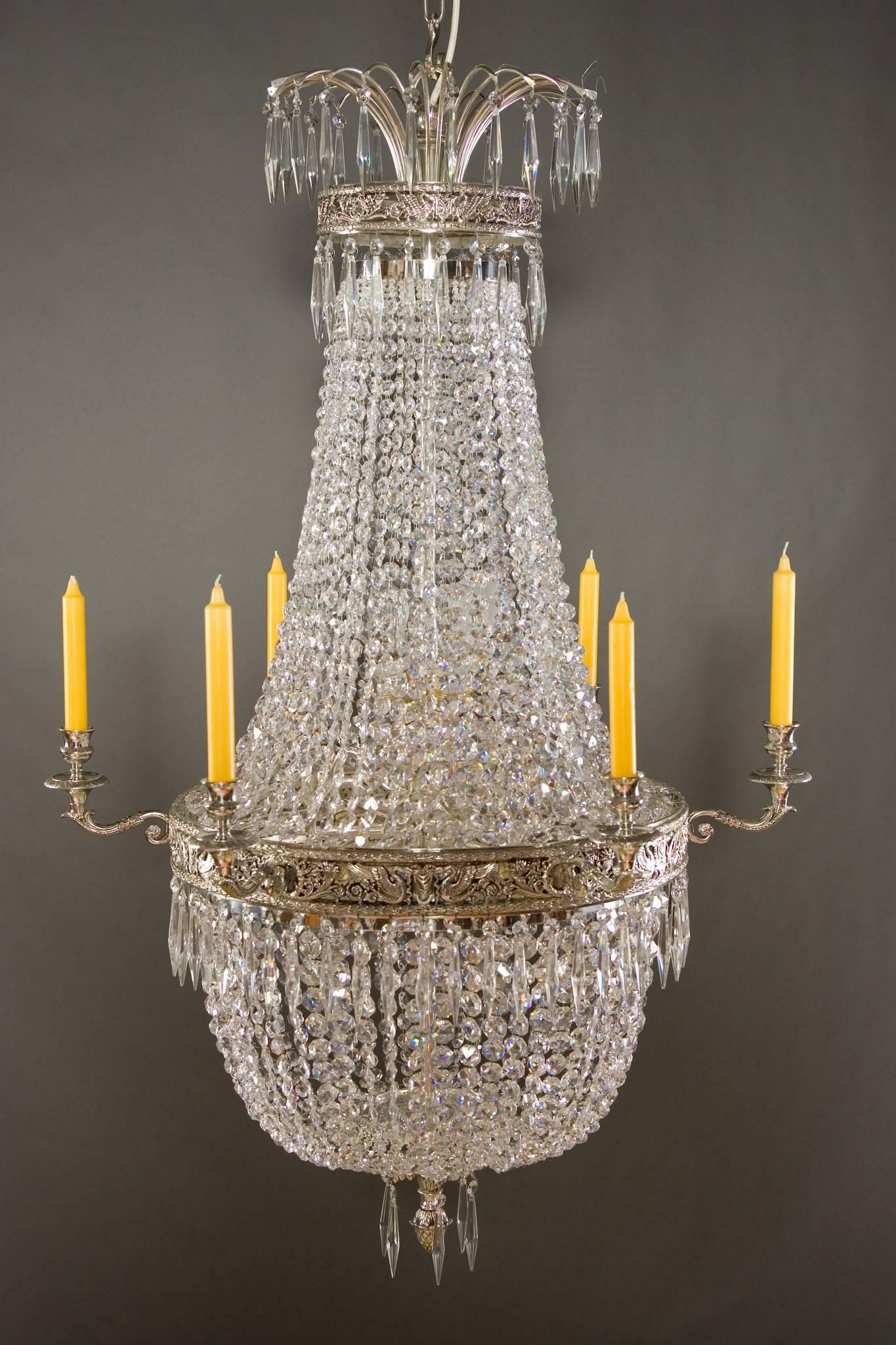 20th Century Empire style basket chandelier

Classicist basket chandelier in Empire style.
Finely cast, Bronze silvered. Adorned with engraved swans and pearl cords.

(F-Ra-20).