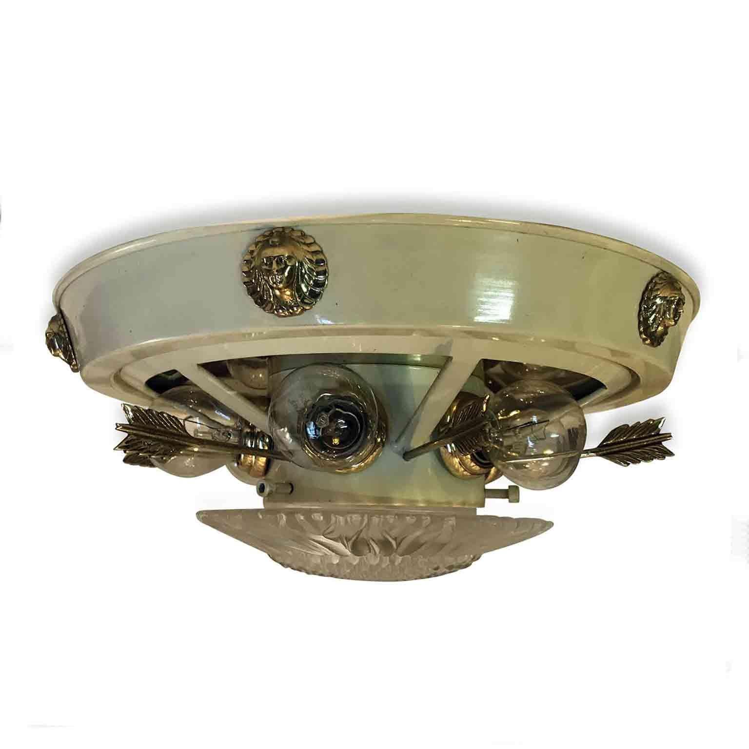 Italian 1980s ceiling light by Banci Firenze, an Empire style circular brass and ivory color painted ceiling fixture, decorated with six cast brass masks on the larger perimeter and six cast brass arrows between each light bulbs. In the center, a