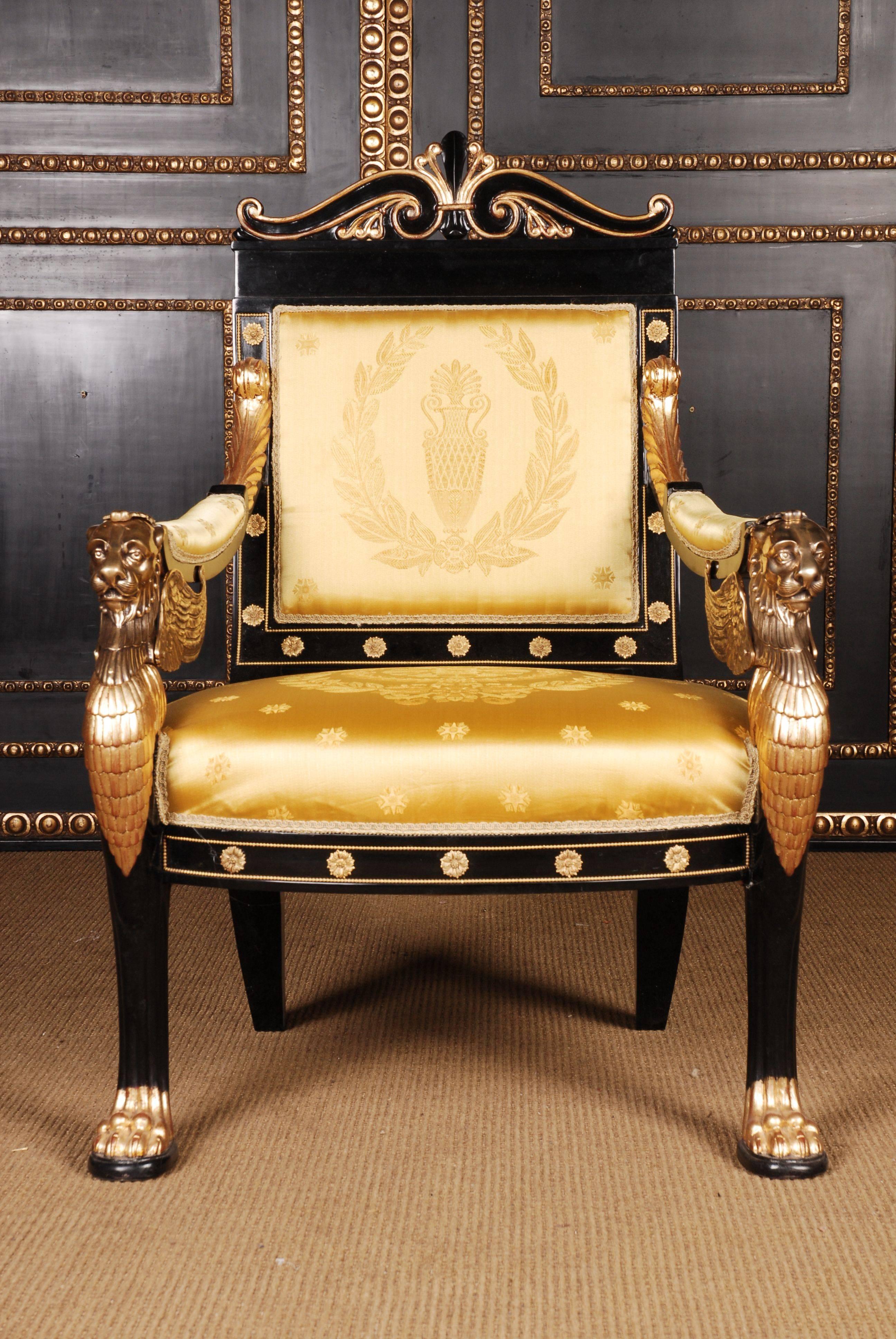 20th century Empire style lion armchair

Imperial stylish lion armchair in Empire style.
Finely detailed carving work on solid ebonized beechwood. Gilded. Winged, protruding lions heads in bronze.

Delivery time takes about 6-8