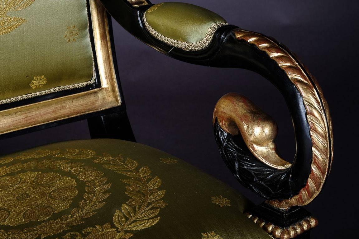 Napoleonic pavilion armchair in Empire style.
Very exact fine-carved sculpture made of solid, blackened beechwood. Poliment gold-plated. Scratched frame on plastically carved legs ending in claws. Armrests volute-shaped bent in swan head.
