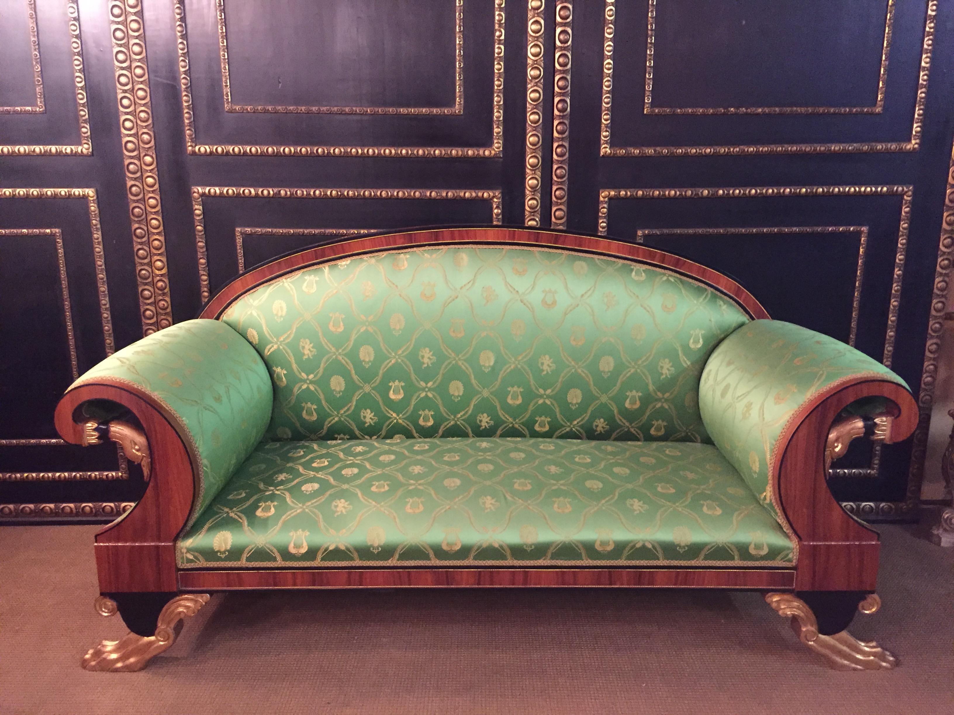 Empire Swan  canapé in the style of Classicism (1810). Exotic palisander on solid beechwood. Partially ebonized and gilded.
On each side a carved swan's head.
Very high quality satin fabric.
The feet carved in paws.