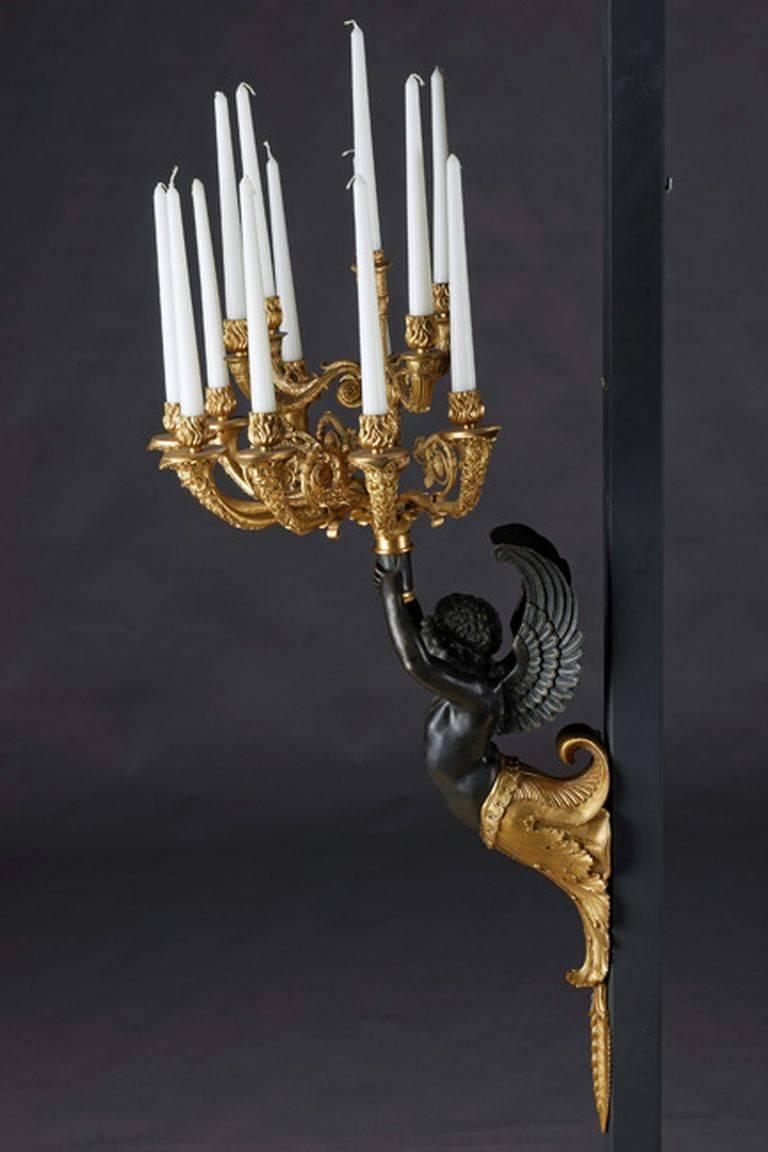 Imperial Empire wall girdle to Antoine-André Ravrio 1759-1814.
Bronze, gilded or partly dark patinated. From acanthus of fullplastic herme / Amor adult with, holding a vase as a carrier for light bulbs. Outward slender, multi-jointed baluster shank