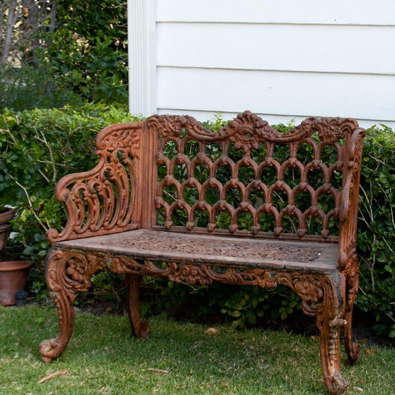 An early 20th Century, antique small British Victorian style cast iron garden bench attributed to Carron Foundry, in good condition. This heavy and ornate English garden furniture is particularized with scrolls and acanthus leaves. A charming