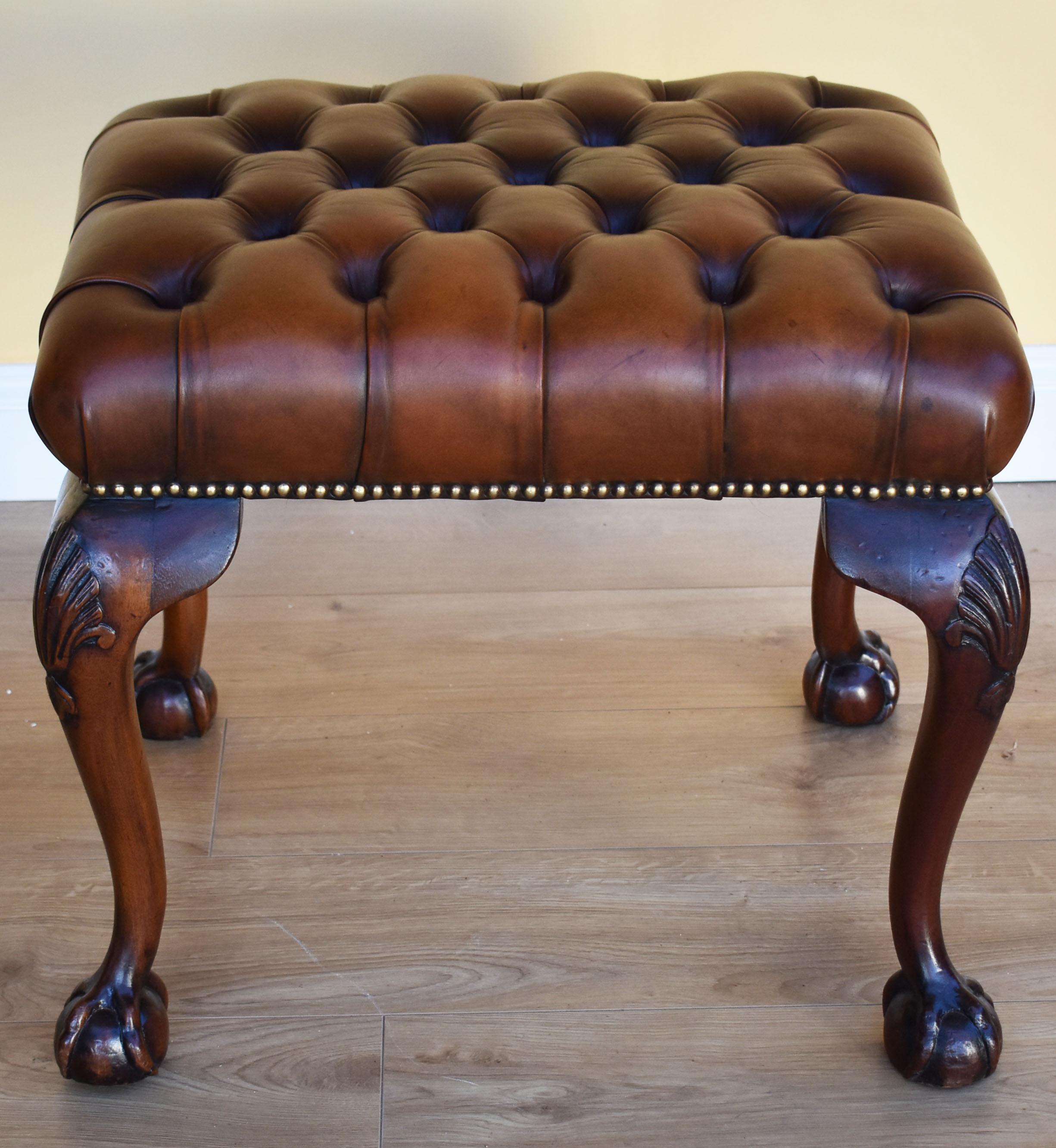 For sale is a fine quality Queen Anne style deep buttoned leather foot stool. The stool has been upholstered in leather hide and has been dyed by hand. It stands on elegant cabriole legs terminating on claw and ball feet. All of the upholstery is in