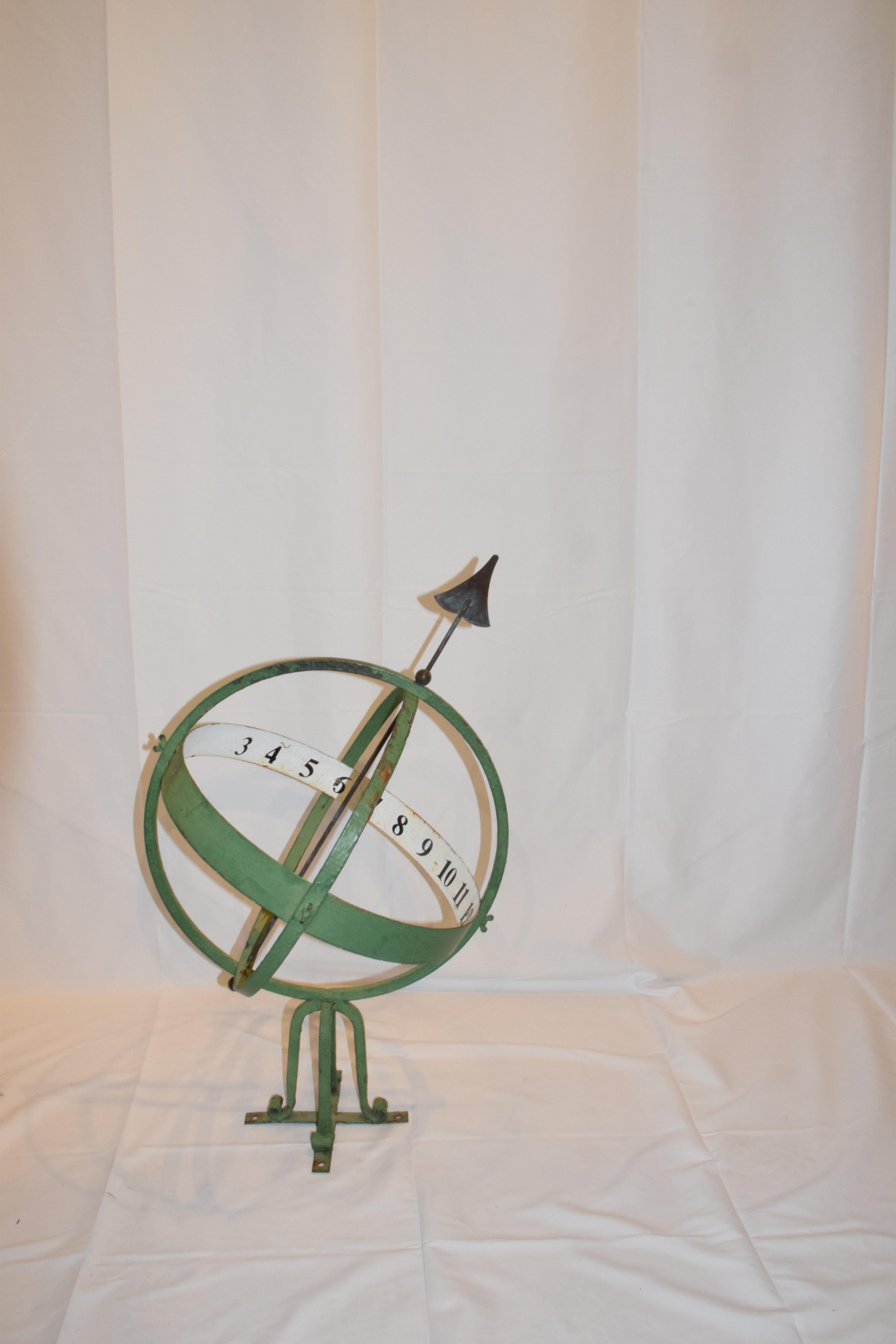 Found in England this 20th century armillary sphere is pierced with an arrow and mounted on a four foot scrolled base. The scroll base is mounted on a cross bar which can be attached to a surface, four holes are provided for additional stability.