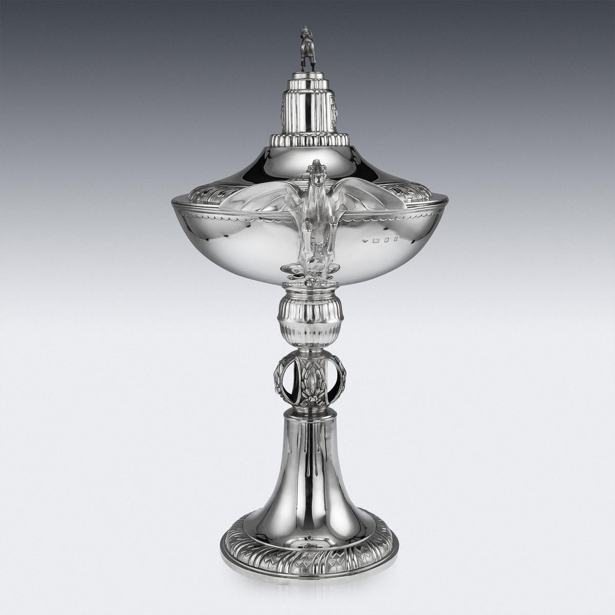 Antique 20th century English Art Deco solid silver monumental trophy cup and cover, shaped as a cocktail glass, the lid, stem and base decorated with stylized laurel leaves, sides applied with beautifully modelled twin cast Pegasus handles, the lid