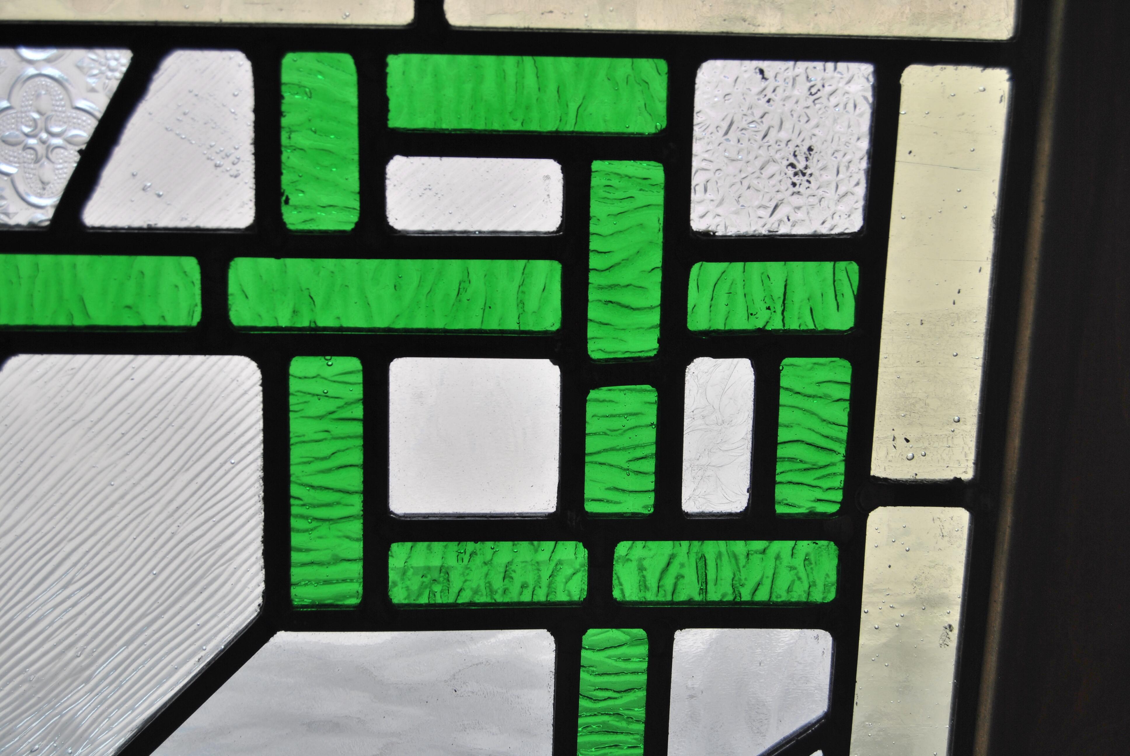 This is a leaded stained glass window that was made in England, circa 1970. The window is properly made, using lead as the structural support for the individual pieces of glass. The window is a great example of the Art Deco style. It has a light