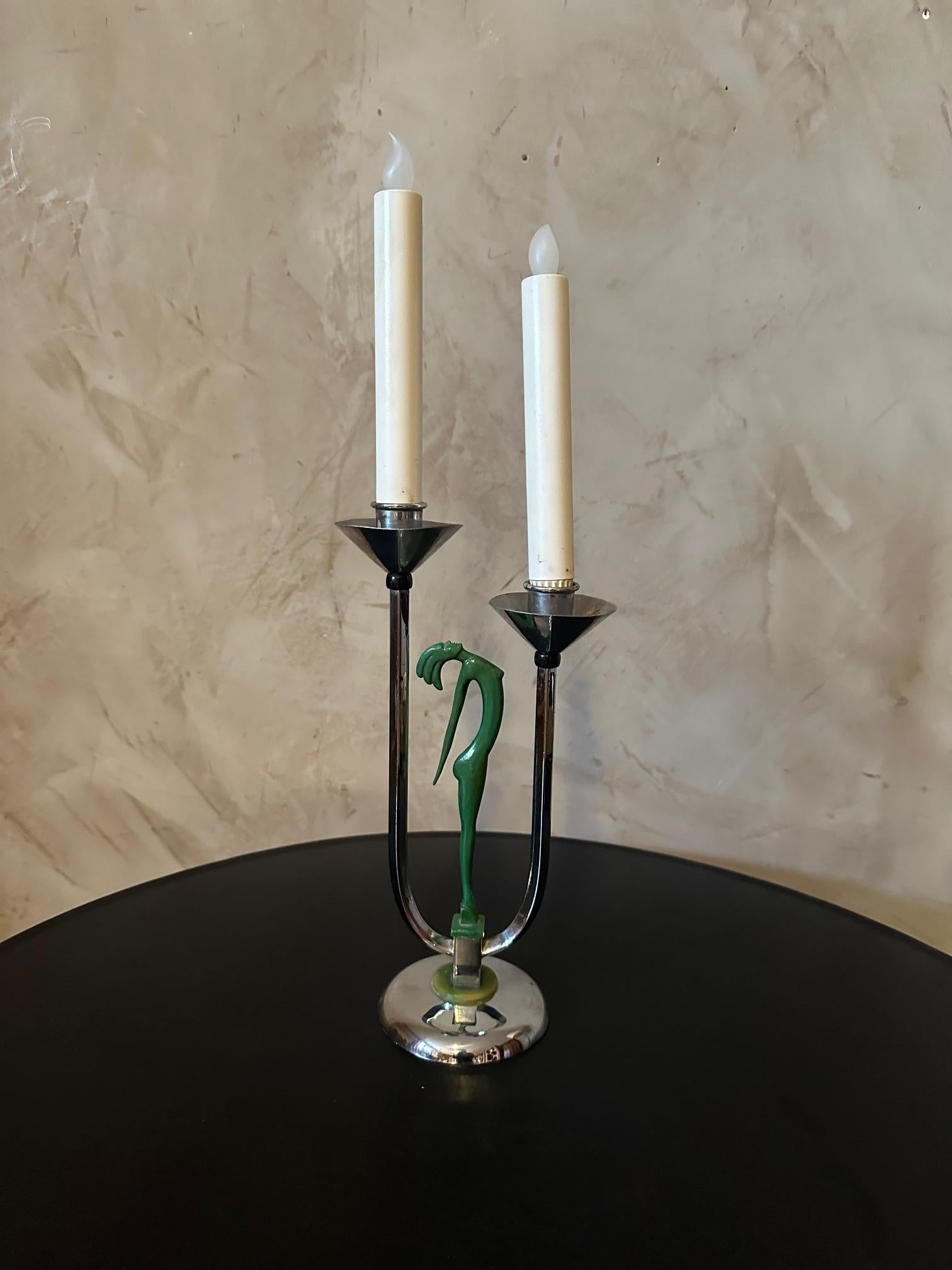 Very beautiful art deco candlestick in good condition in chrome metal which is part of a collection of models intended for the General Electric Company (GEC) of England representing the silhouette of a stylized woman in bronze with a green patina