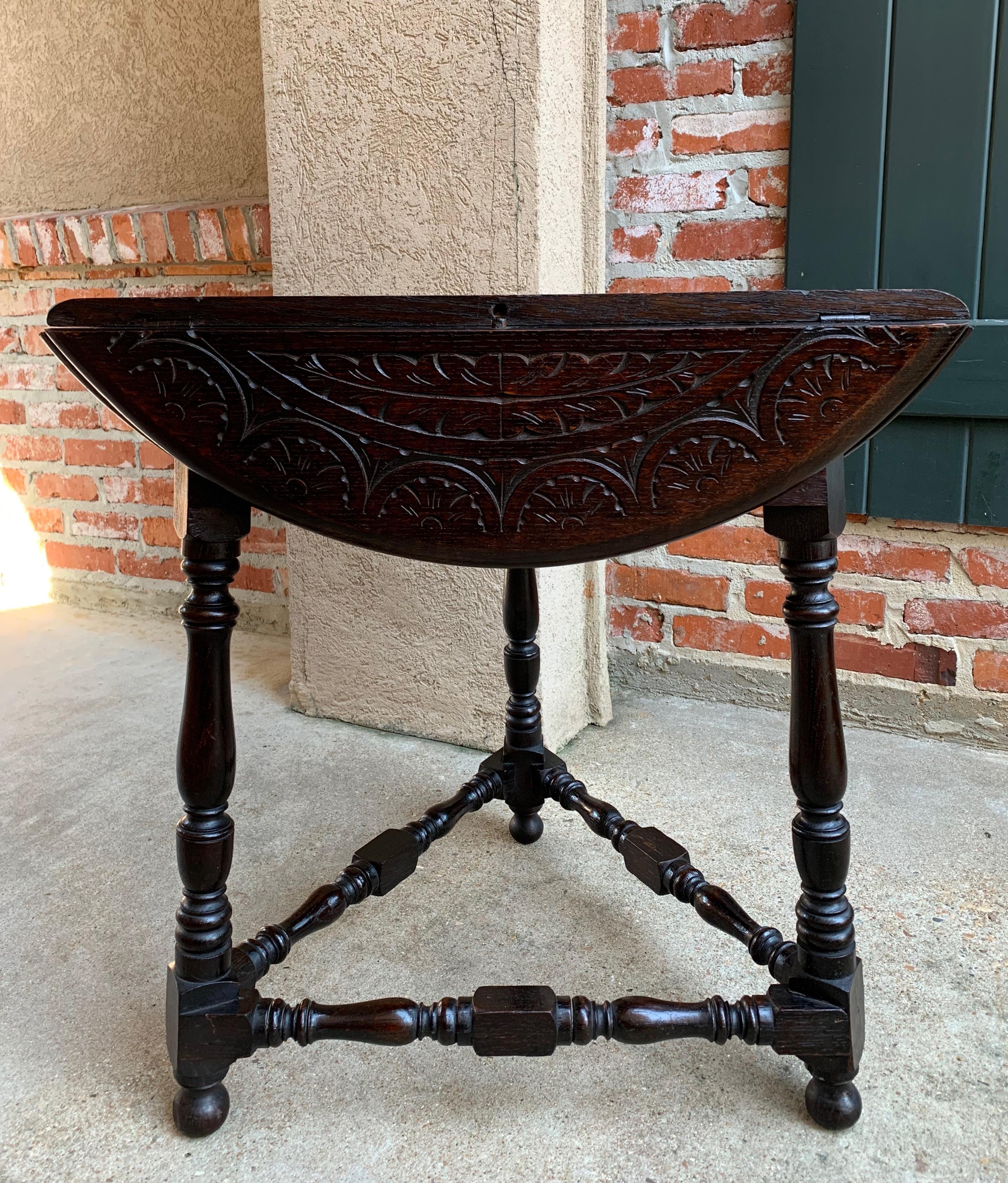 Direct from England, a charming antique English carved oak “handkerchief” table, with leaves down it can be tucked in any small place or corner. Turn the top slightly and all three leaves open up to make a lovely round table top!~
~Fully carved on