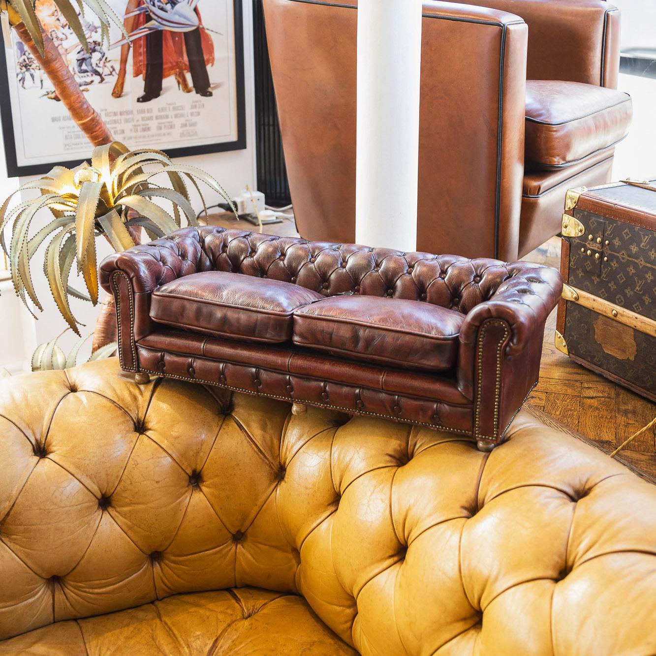 A superb 20th century Timothy Oulton leather mini chesterfield sofa. One of the most elegant models with soft cushion seating, this is a fashionable yet quirky item of furniture capable of uplifting the interior space of any contemporary or