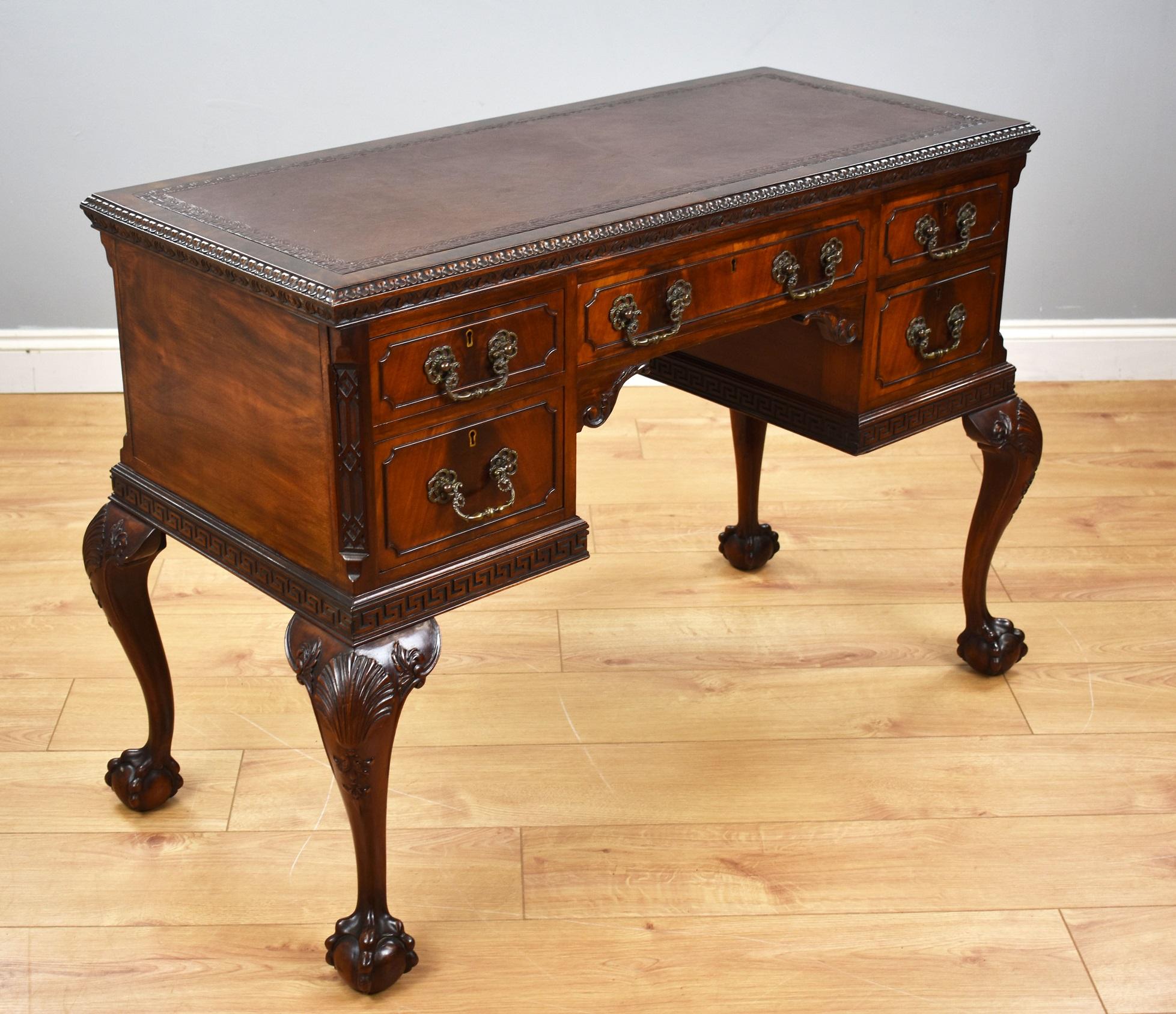 For sale is a fine quality antique Chippendale style mahogany writing table. The top is banded in superb flame mahogany veneer surrounding the inset writing surface, the edge decorated with fine carved mouldings. Below this there is an arrangement