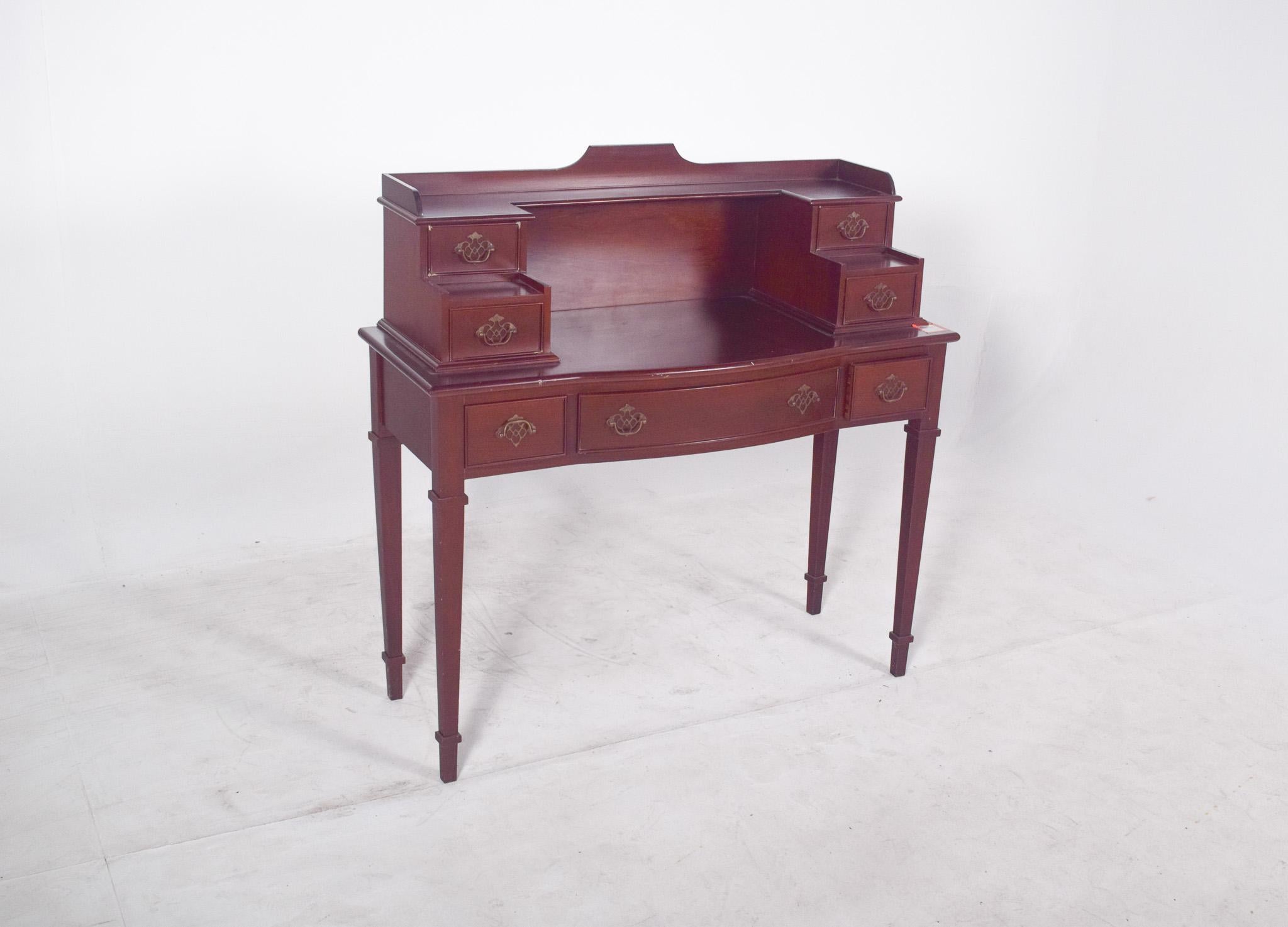 English colonial-style desk. With its elegant lines and light structure, the recessed top is framed by two small side modules with drawers, creating a symmetrical composition. At the bottom, there are three more drawers that don't interfere with the