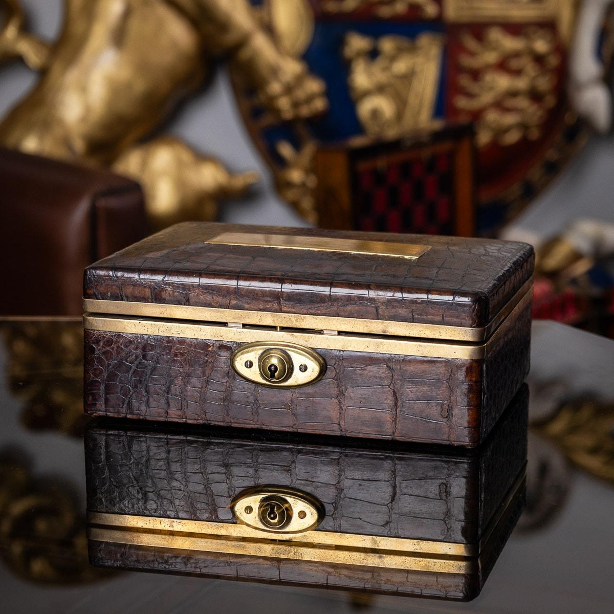 Antique early 20th Century crocodile leather bound jewellery box. This charming box features a brass plaque, brass surround and locking mechanism. The box features a velvet lined interior, perfect to store an assortment of jewellery. The box does