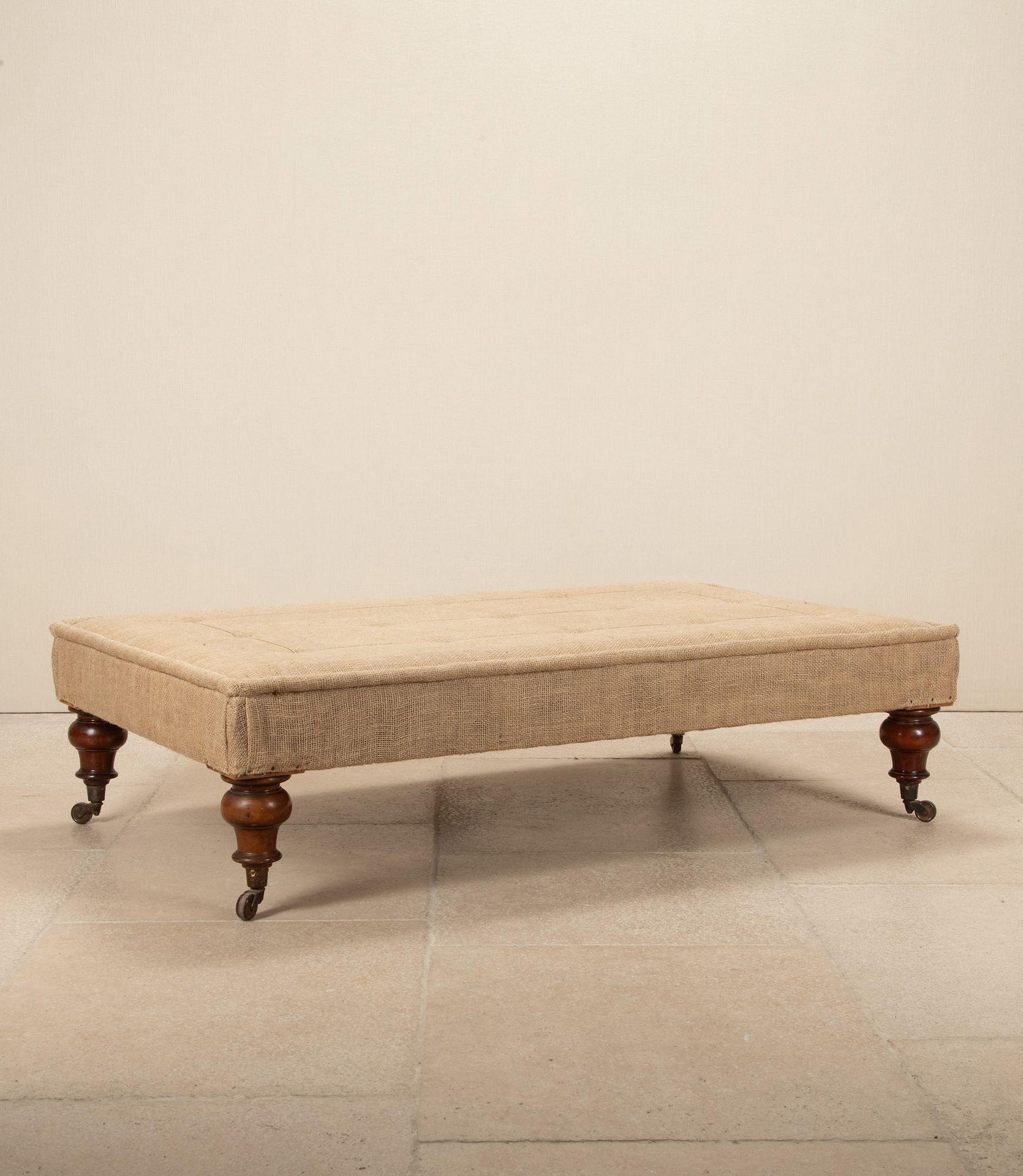 A large 20th Century English ottoman in deconstructed style on Victorian mahogany legs.
