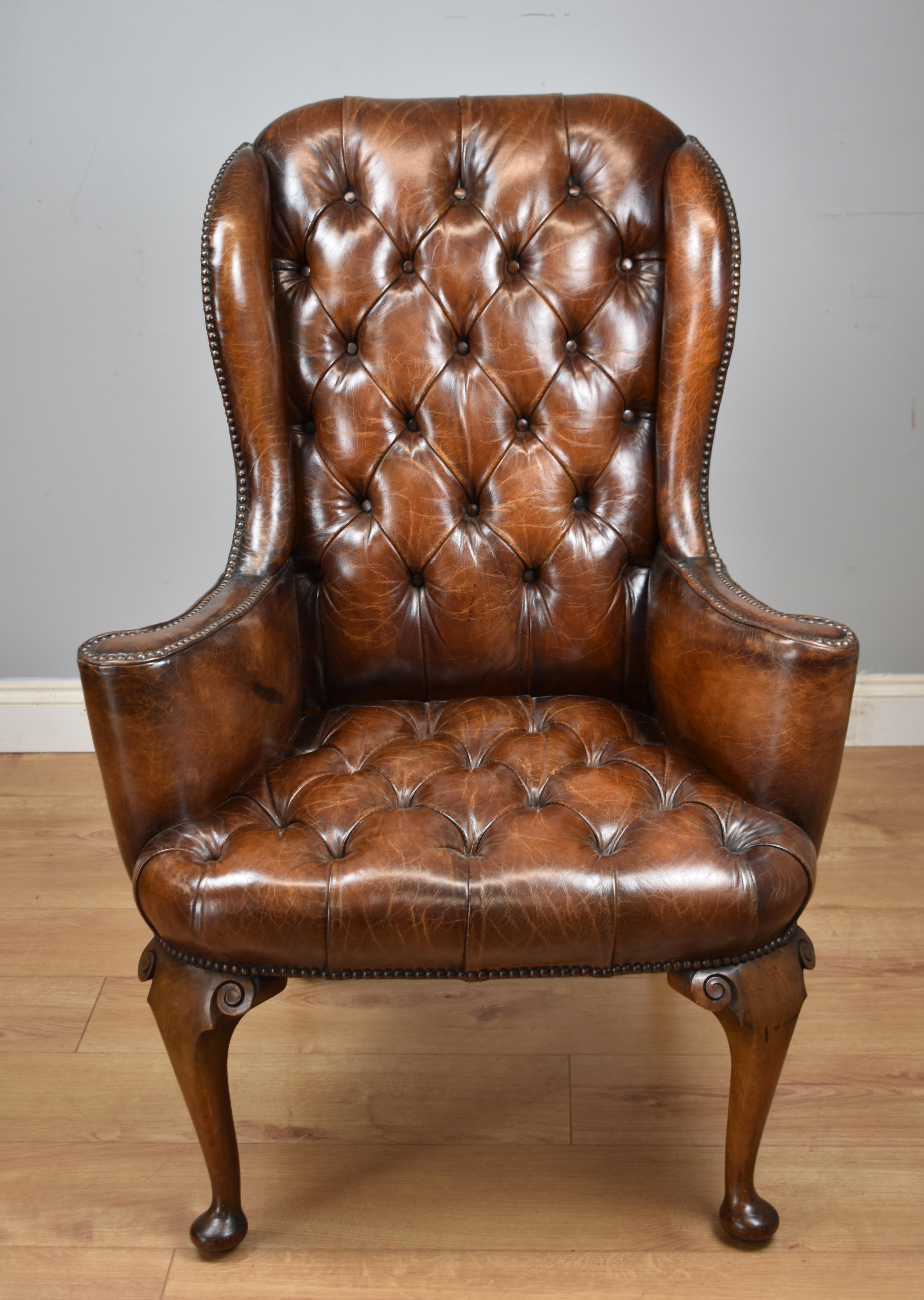 For sale is a fine quality Early 20th century hand dyed distressed brown English leather wingback armchair of small proportions. The chair has a deep buttoned back flanked by two wings, above a deep buttoned seat, with two scrolled arms. The chair