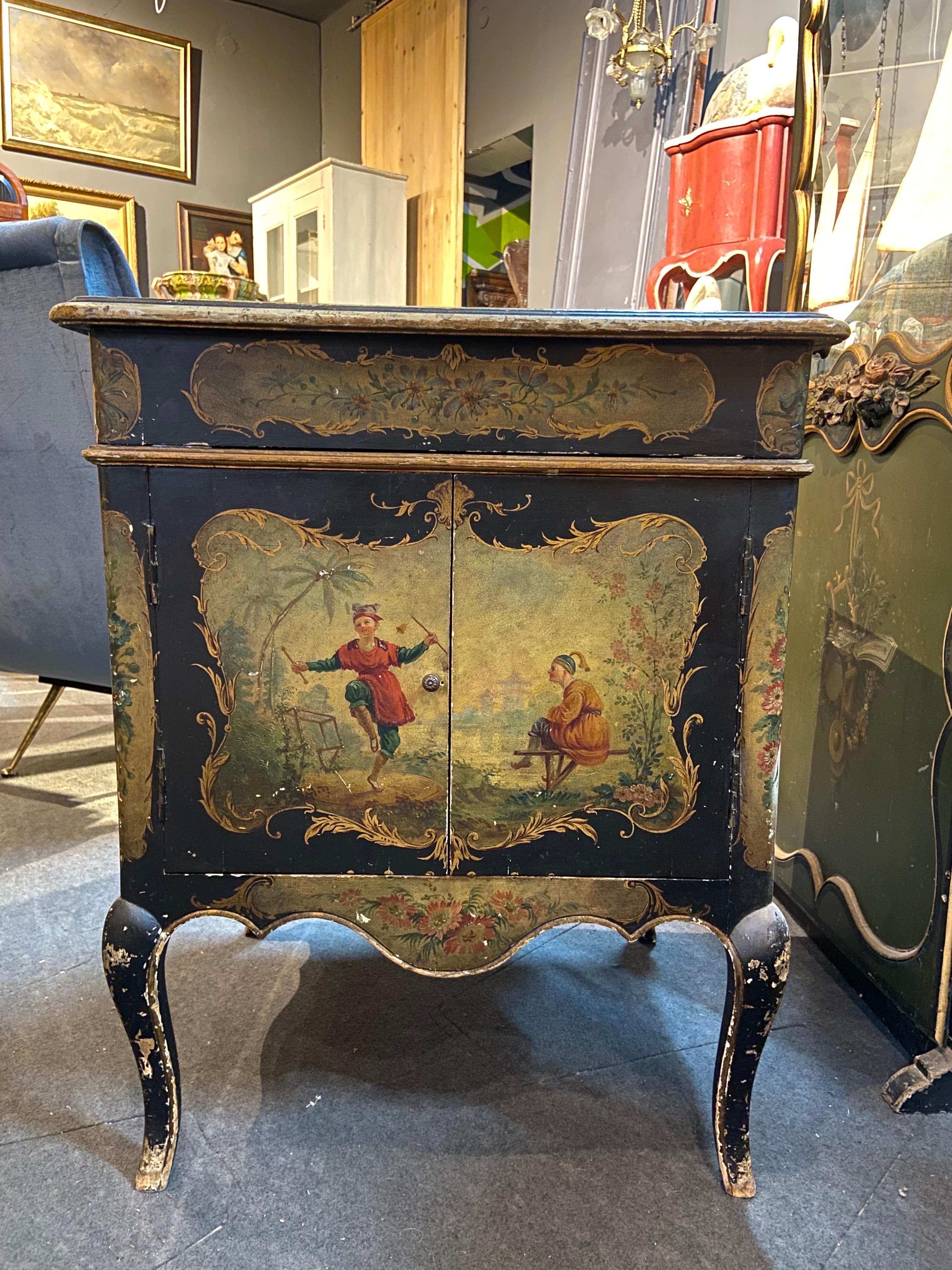 British music cabinet with decoration of Chinoiserie, foliage and musical instruments. It opens with a flap with articulated shutters and two leaves. 
It is not in working condition but is a curious and rare item. It is still in its original
