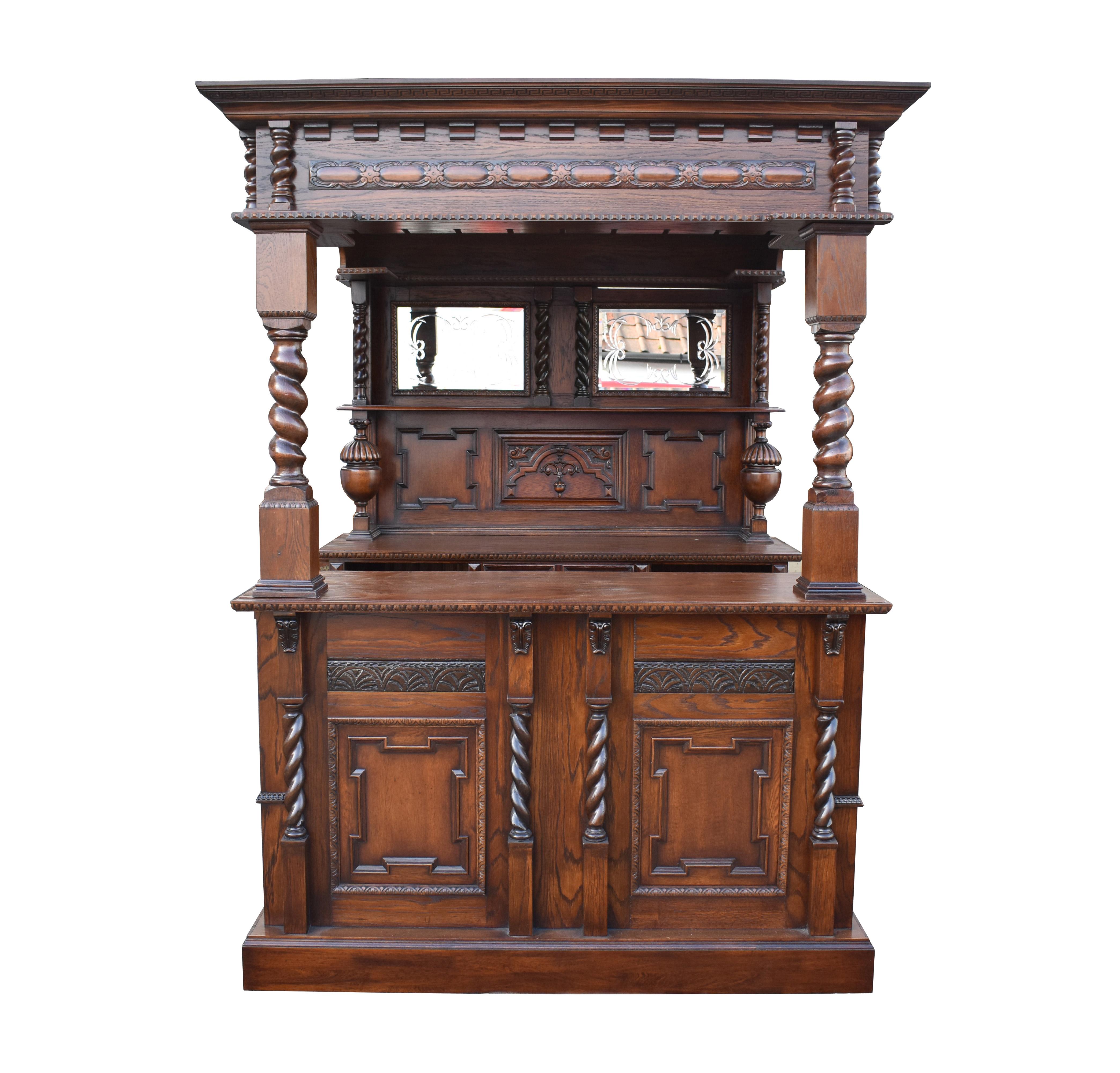 For sale is a good quality 1920's Jacobean style oak bar. The canopy top having two stained glass panels, above a mirror back with each mirror being hand engraved. Below this Jacobean style carvings, flanked by bulbous supports and barley twist