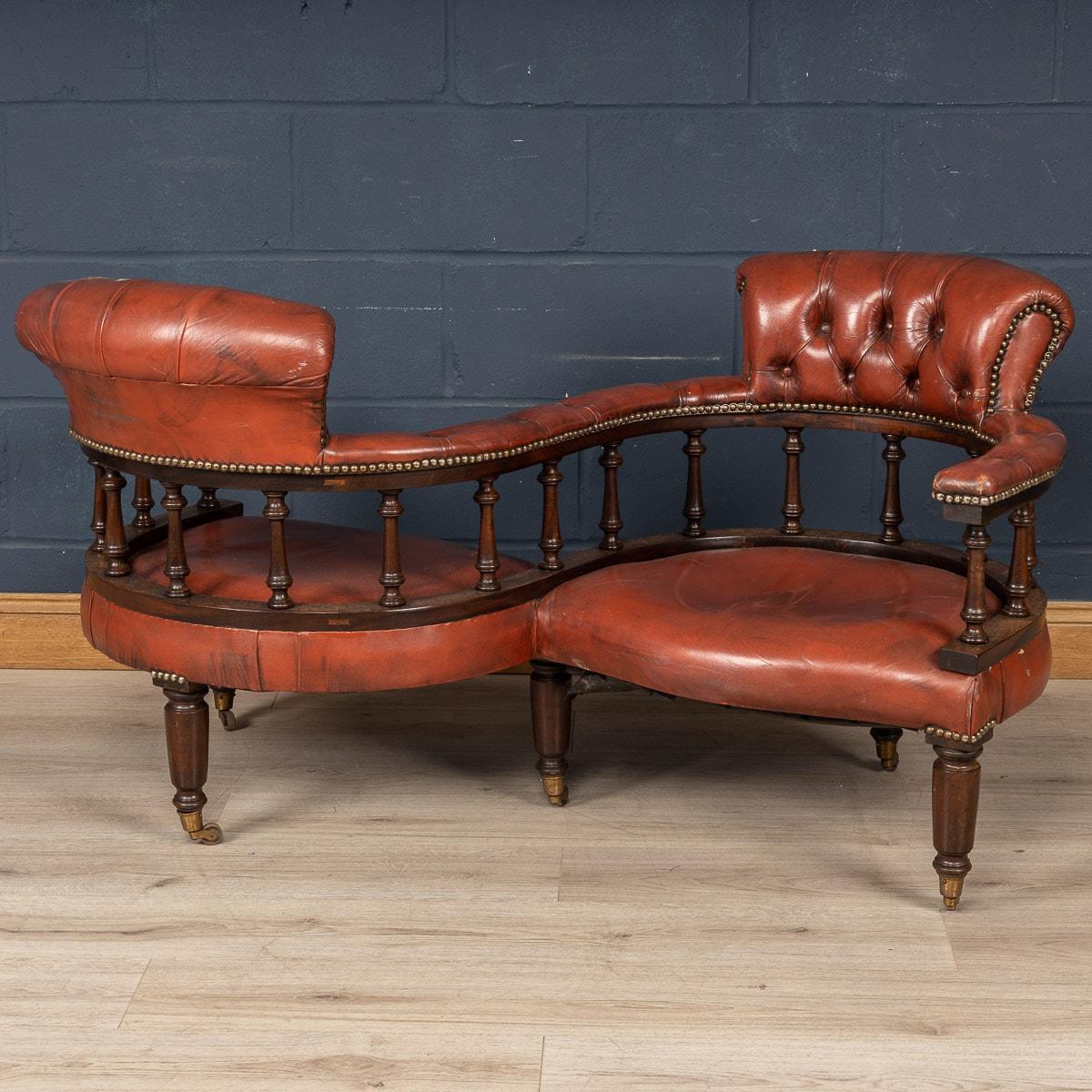 One of the most unusual chairs: a conversation seat or love seat, handmade in England and upholstered in the finest leather. Dating to the middle of the last century, its fluid S curve frame, button down seating and mahogany legs make this item a