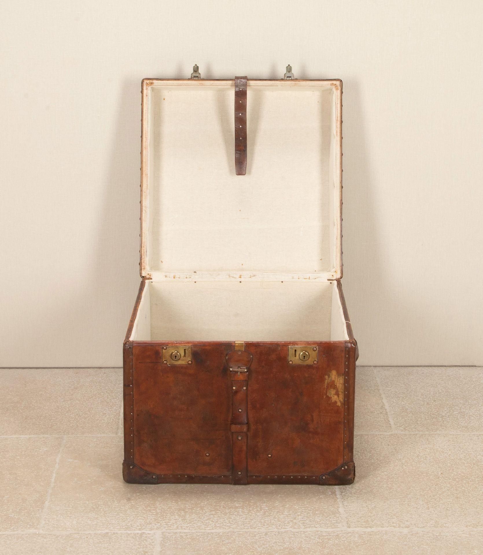 Large 20th Century English leather trunk. With fabulous deep patination consistent with decades of polishing and original cream linen interior. With copper studs and brass locks and straps. Monogram, stamped M.A.T. Ideal coffee table with lots if