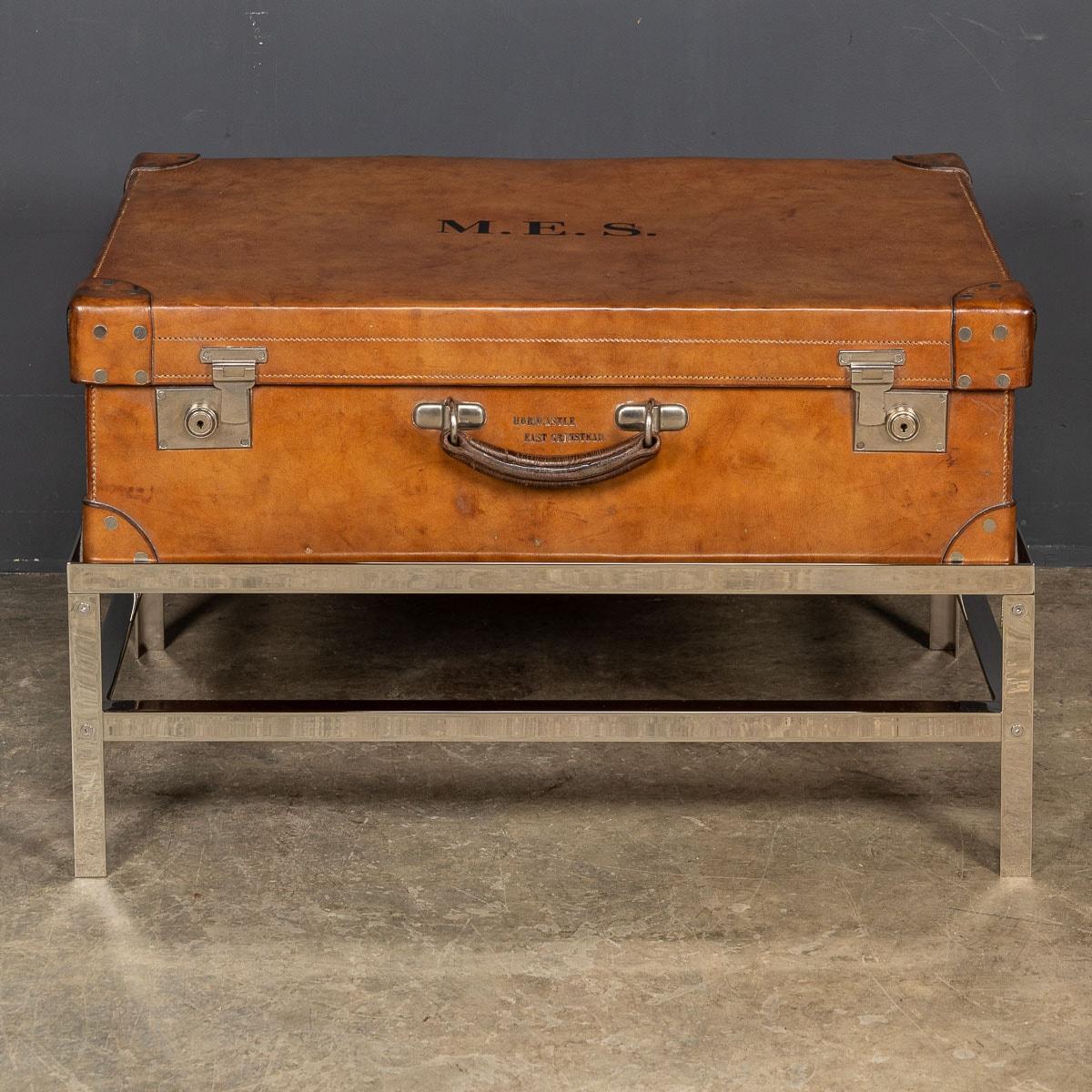 Antique early 20th Century trunk on stand, the inside is lined fabric in a rich burgundy colour, beautifully offsetting the outside natural tan hide colour of the trunk. This trunk comes with original polished metal locks and a leather handle.