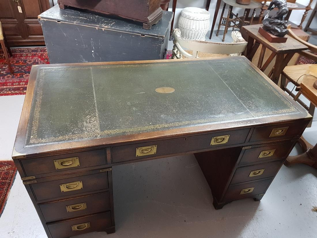 English mahogany colored military/Campaign desk with 8 drawers of which the middle drawer is a key further provided with brass fittings and on both sides of the drawer blocks a handle, this is made by Reprodux England, it is also in good condition