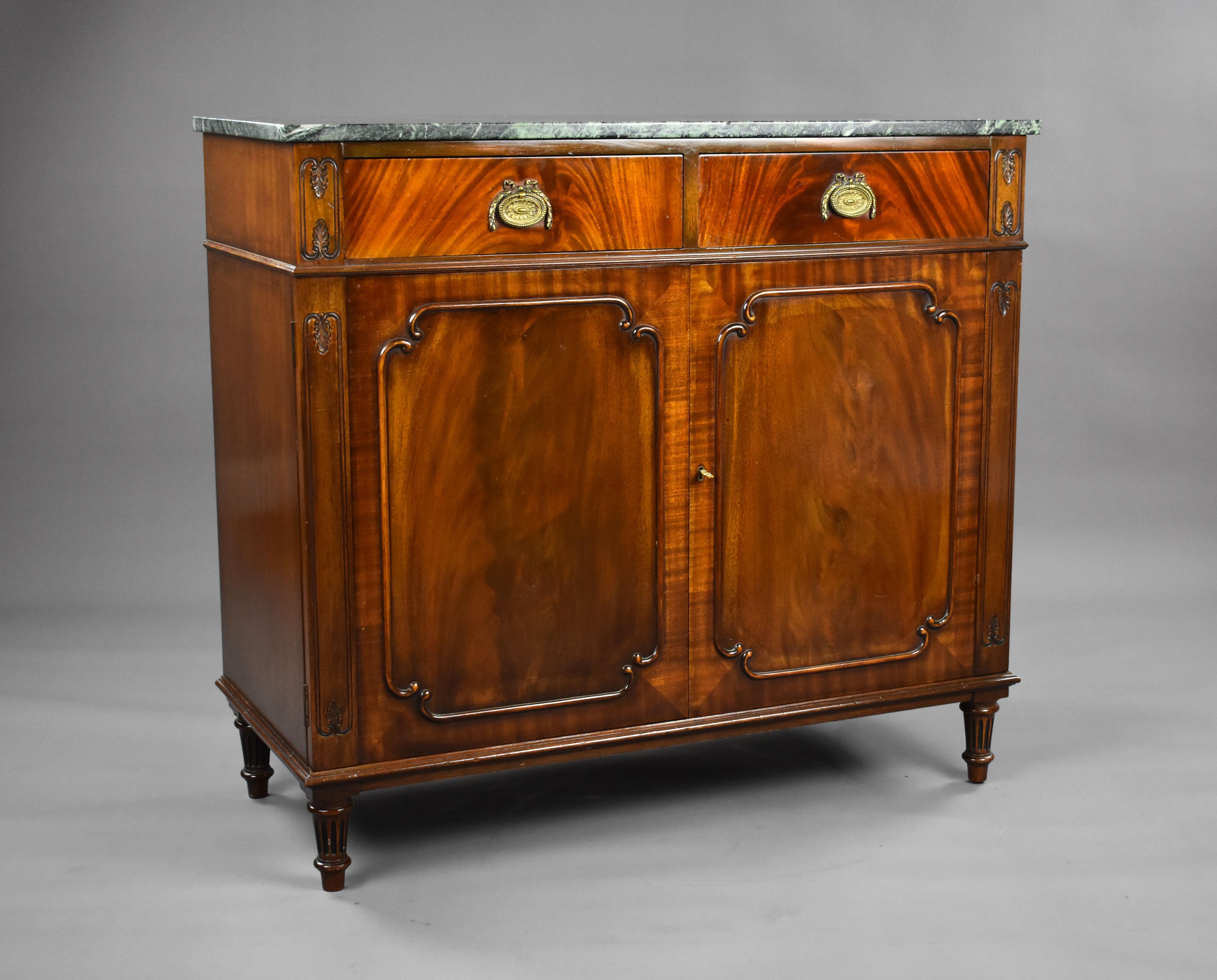 Nous proposons à la vente une armoire à couverts en acajou de bonne qualité, avec un plateau en marbre au-dessus de deux tiroirs, chacun adapté pour les couverts, au-dessus de deux portes de placard reposant sur des pieds tournés. Le meuble est en