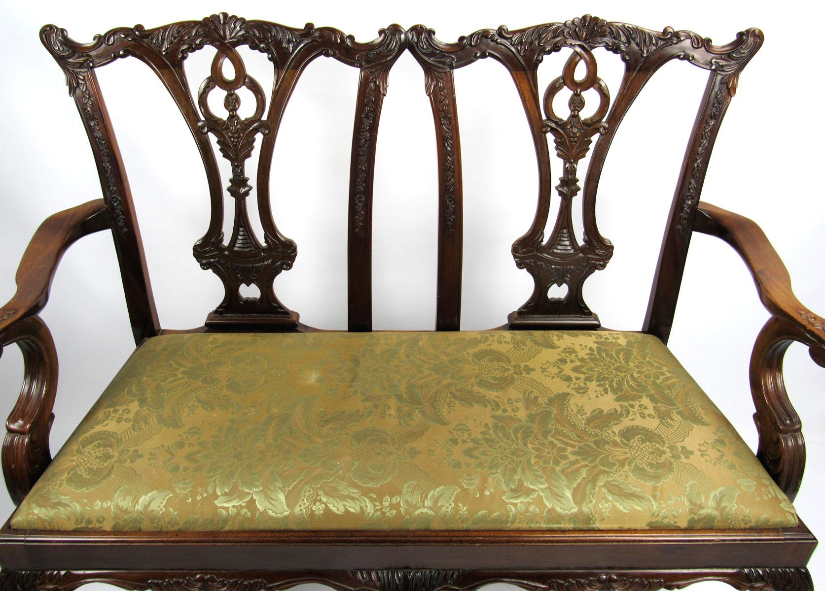 Nicely carved 20th century English mahogany parlor settee with ball and claw feet.