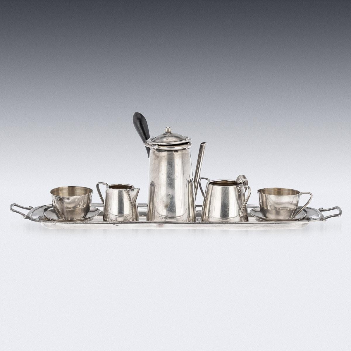 Antique early 20th Century English miniature solid silver seven piece coffee service, comprising of a coffee pot, sugar bowl, tongs, cream jug, and two cups with saucers and a serving tray. A very rare set used to decorate a table in a doll hous.