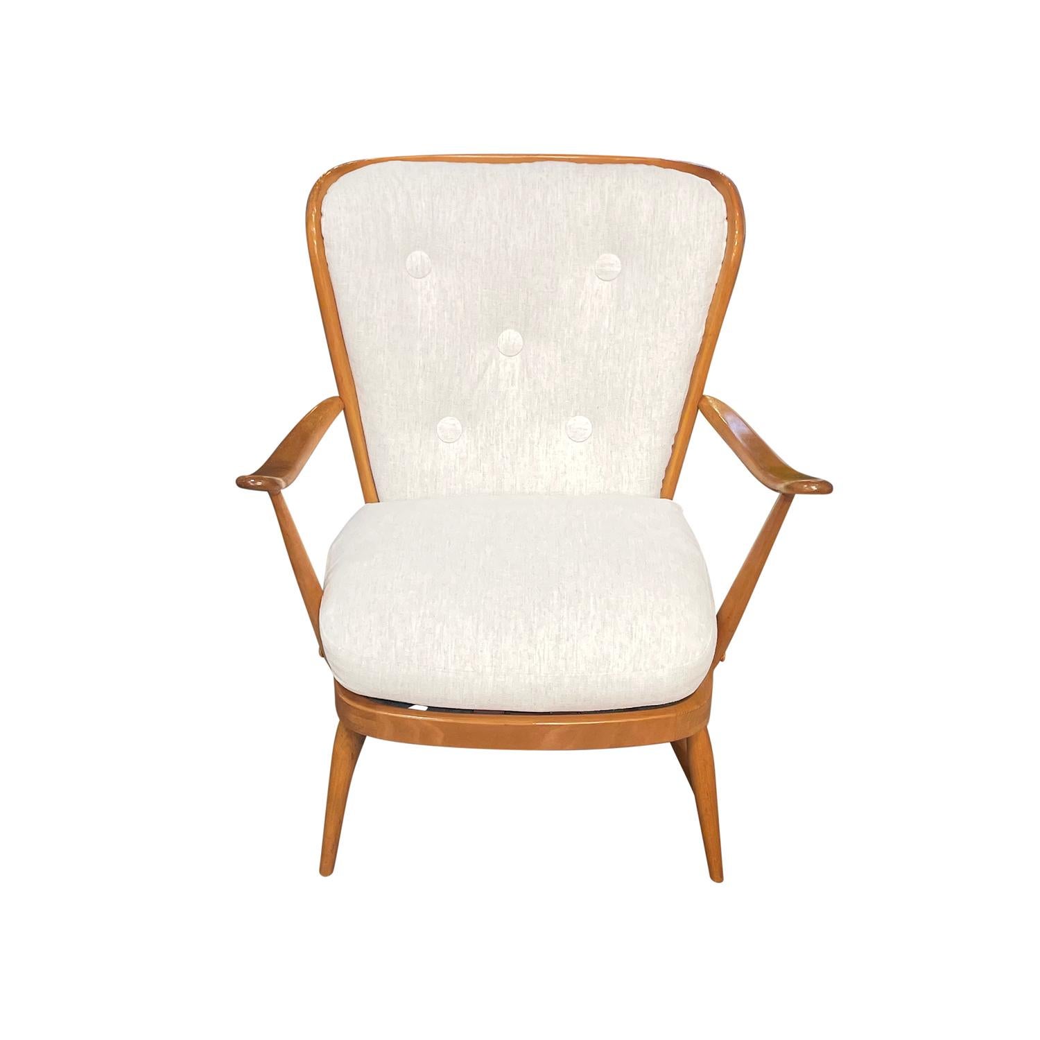 A single, vintage Mid-Century modern English armchair made of hand crafted polished Beechwood, in good condition. The low British side chair has an open, spindled reclined backrest with arched, outstretched armrests. The back rest  is particularized
