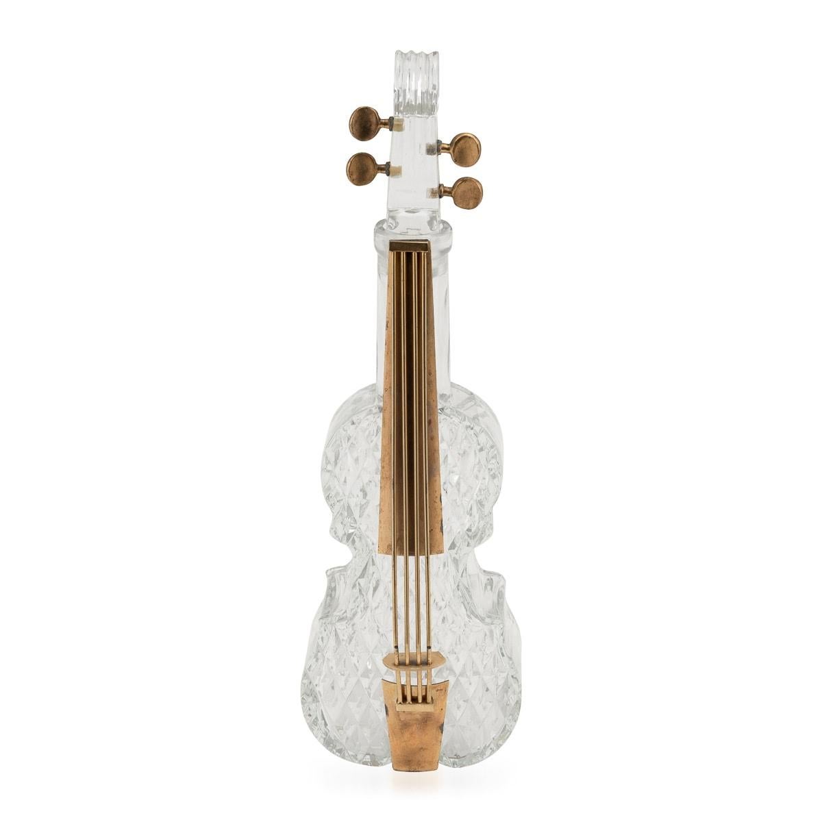 A charming novelty cut glass decanter, a musical ode in the shape of a double bass. Crafted with meticulous artistry in England during the mid to late 20th century, this distinctive decanter was formed using a glass mould, further adorned with
