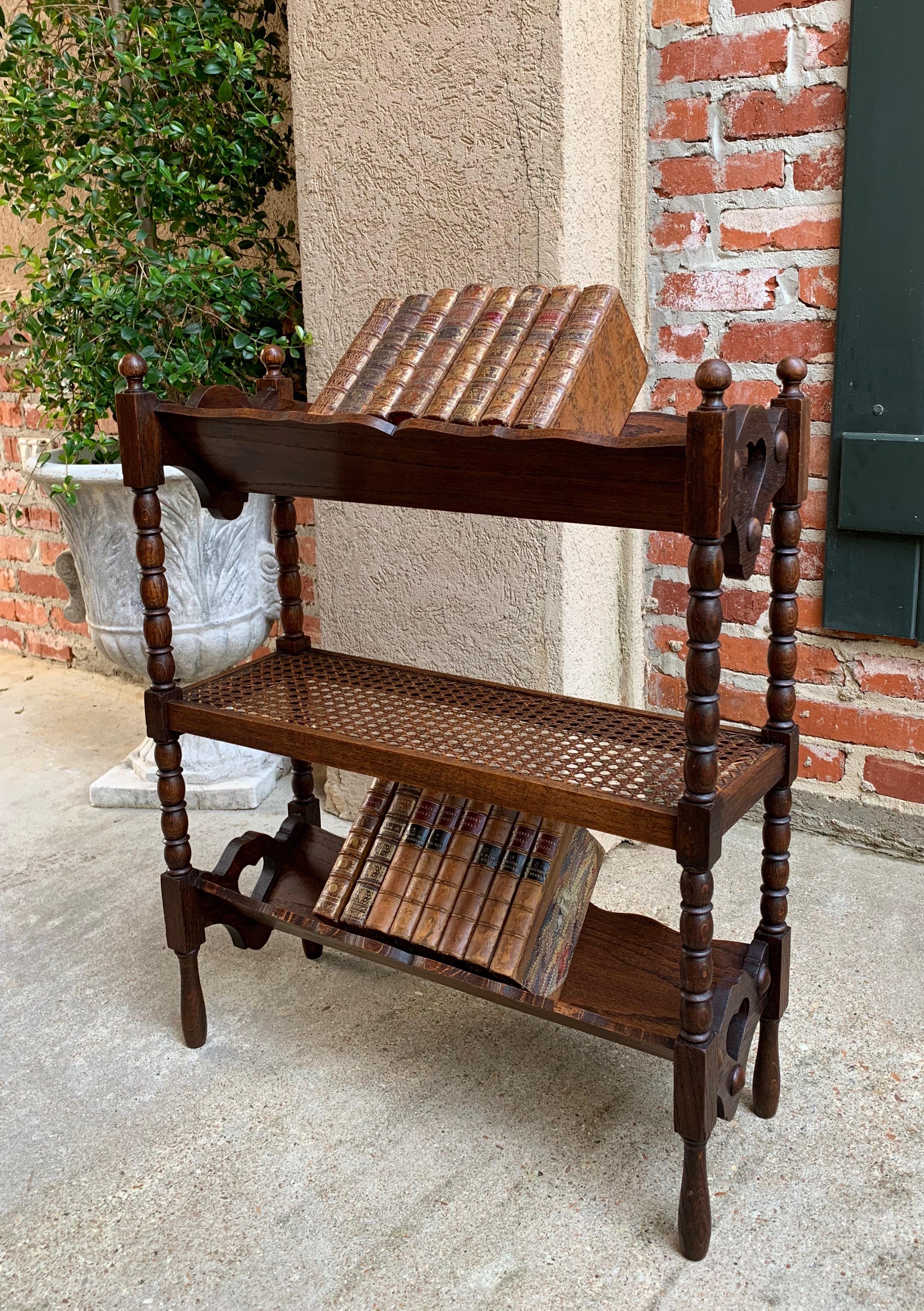 Direct from England, a charming antique English oak book shelf or “book trough” as the British call them!~
~Three levels, with two scalloped edge book ‘troughs’ and it’s original cane center shelf~
~Traditional English “bobbin” turned legs with