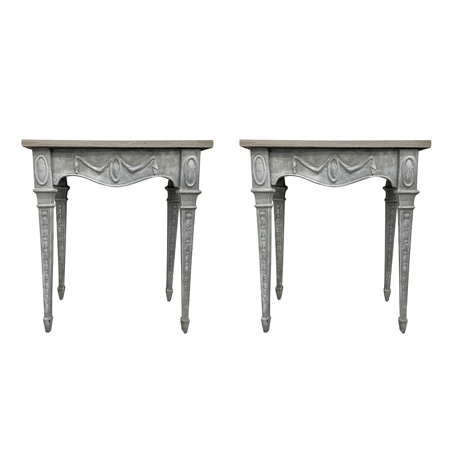 A grey, antique Regency English pair of console tables made of hand crafted cast iron, in good condition. The freestanding end tables are composed with a slate top, standing on four long legs. Wear consistent with age and use. circa 1920, England.