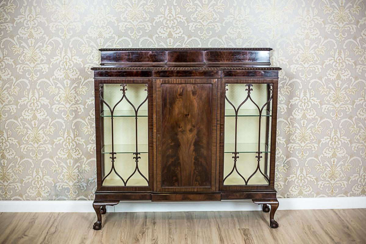 We present you this 20th-century showcase in the Chippendale type.
The whole is in pyramidal mahogany veneer with a beautiful and pronounced graining.
The corpus is three-door, supported on bentwood legs that end with a sphere in the bird