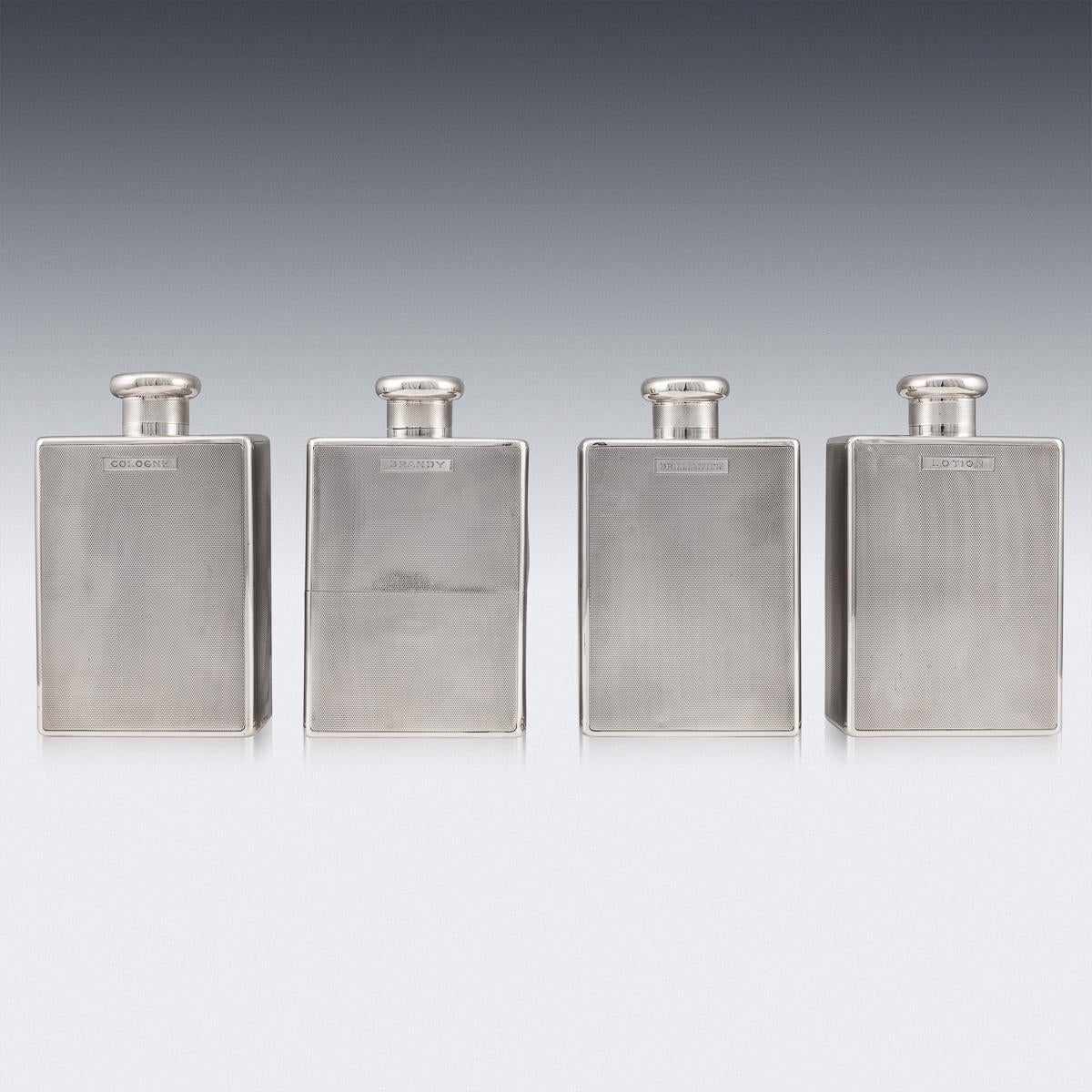 Antique 20th century Art Deco solid silver set of four gentleman's perfume bottles, with silver screw tops, engine turned decoration and engraved; Cologne, Brandy, Brilliantine, Lotion. Hallmarked English silver (925 standard), London, year 1922
