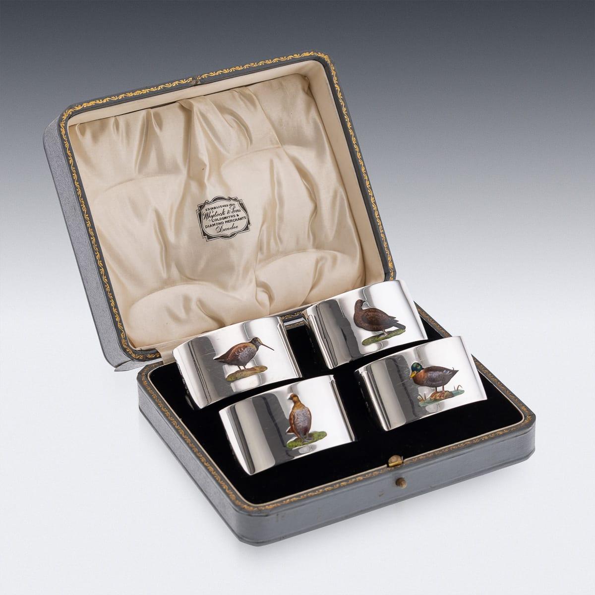 Antique 20th Century English solid silver cased set of four napkin rings depicting enamelled game birds. The napkin rings are of oval form and are of excellent weight. Presented in their original case, these are a wonderful addition to any dining